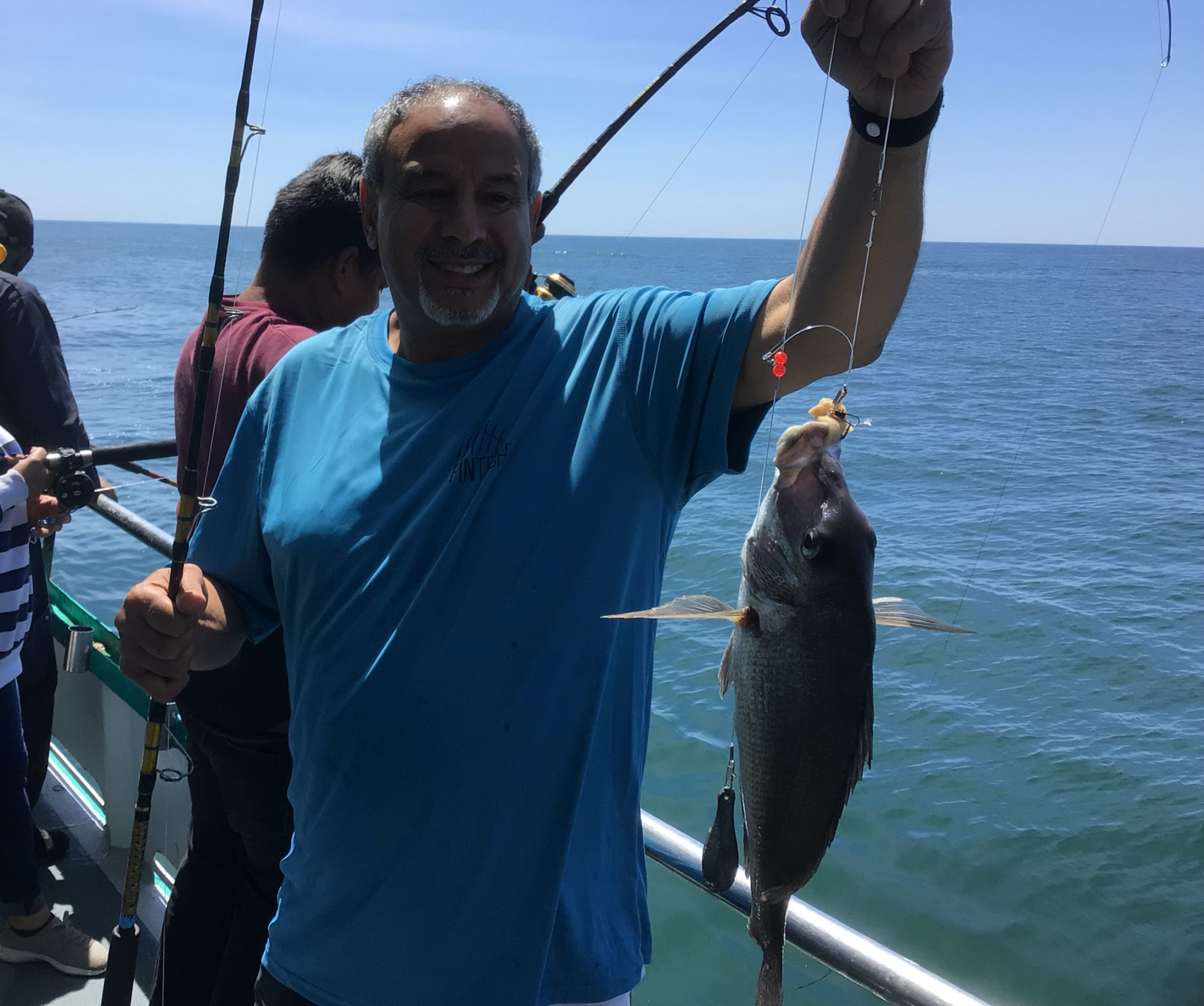 a person holding a fish on a boat in a body of water