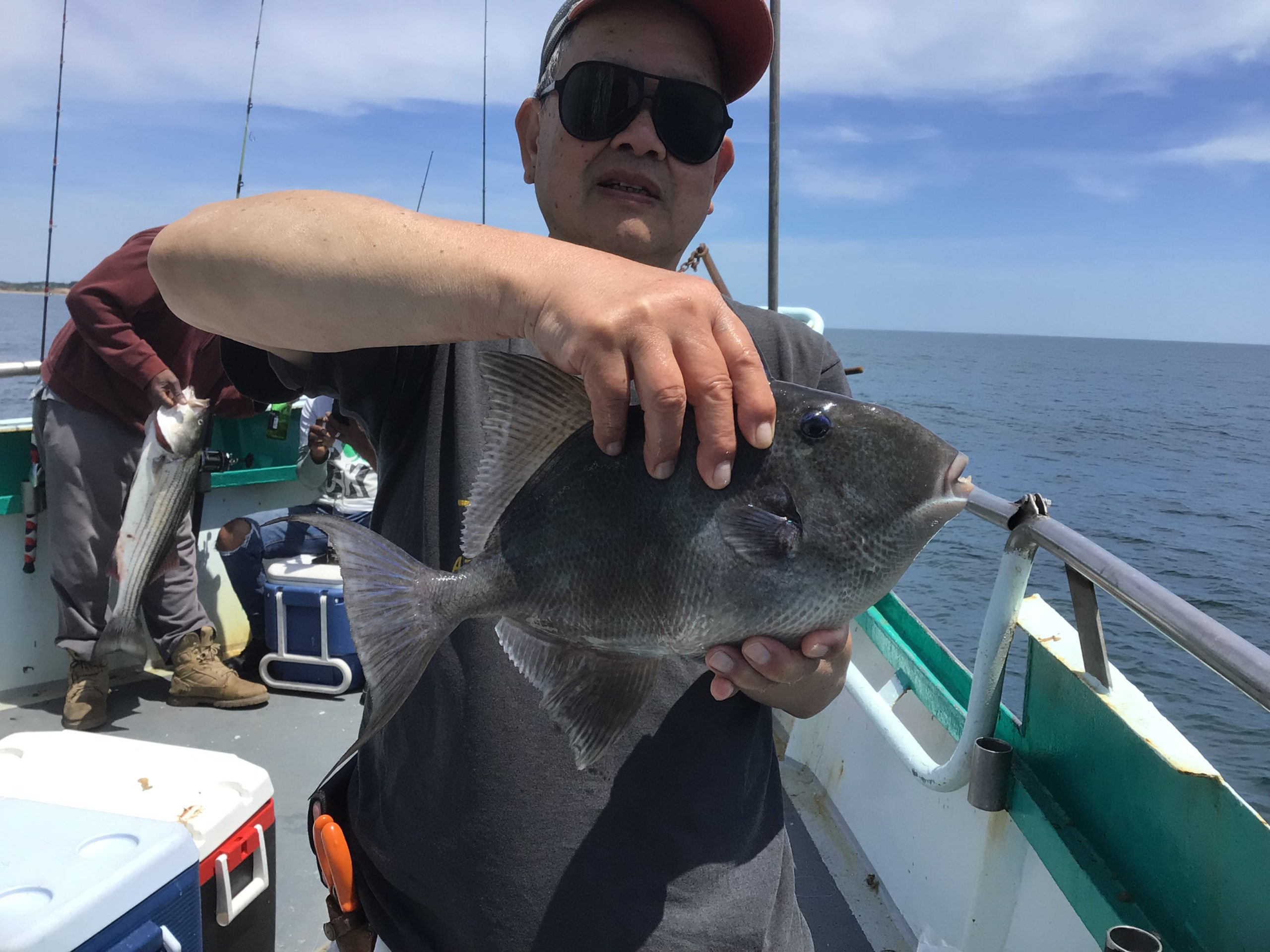 a man holding a fish on a boat