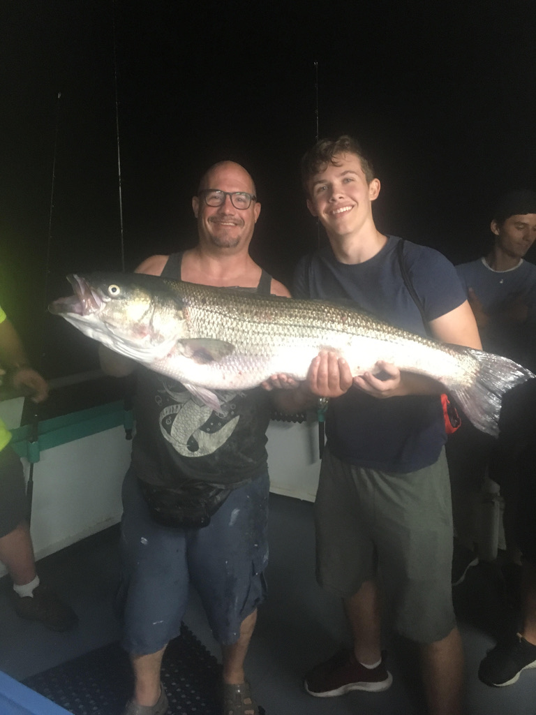 a person holding a fish posing for the camera