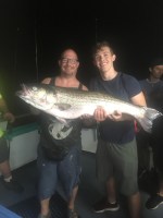 a person holding a fish posing for the camera