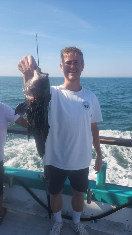 a man and a woman standing in front of a body of water