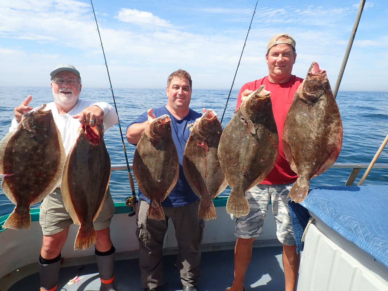 a man holding a fish on a boat
