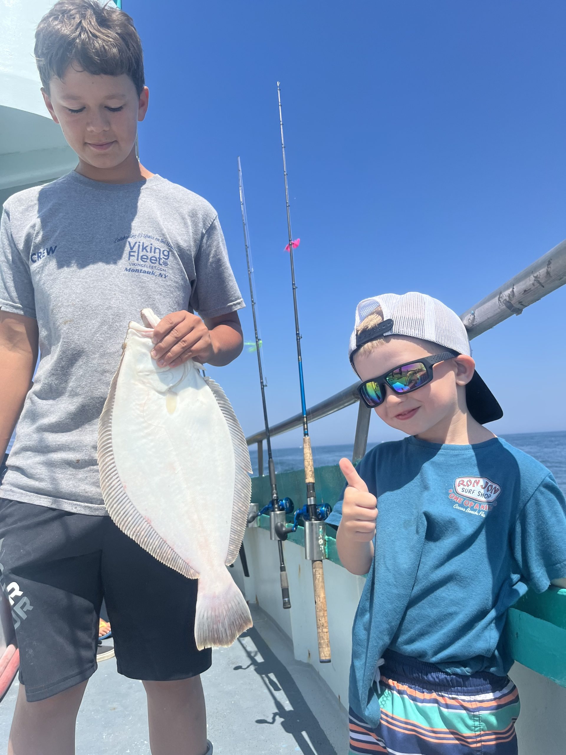 a man and a woman holding a fish posing for the camera