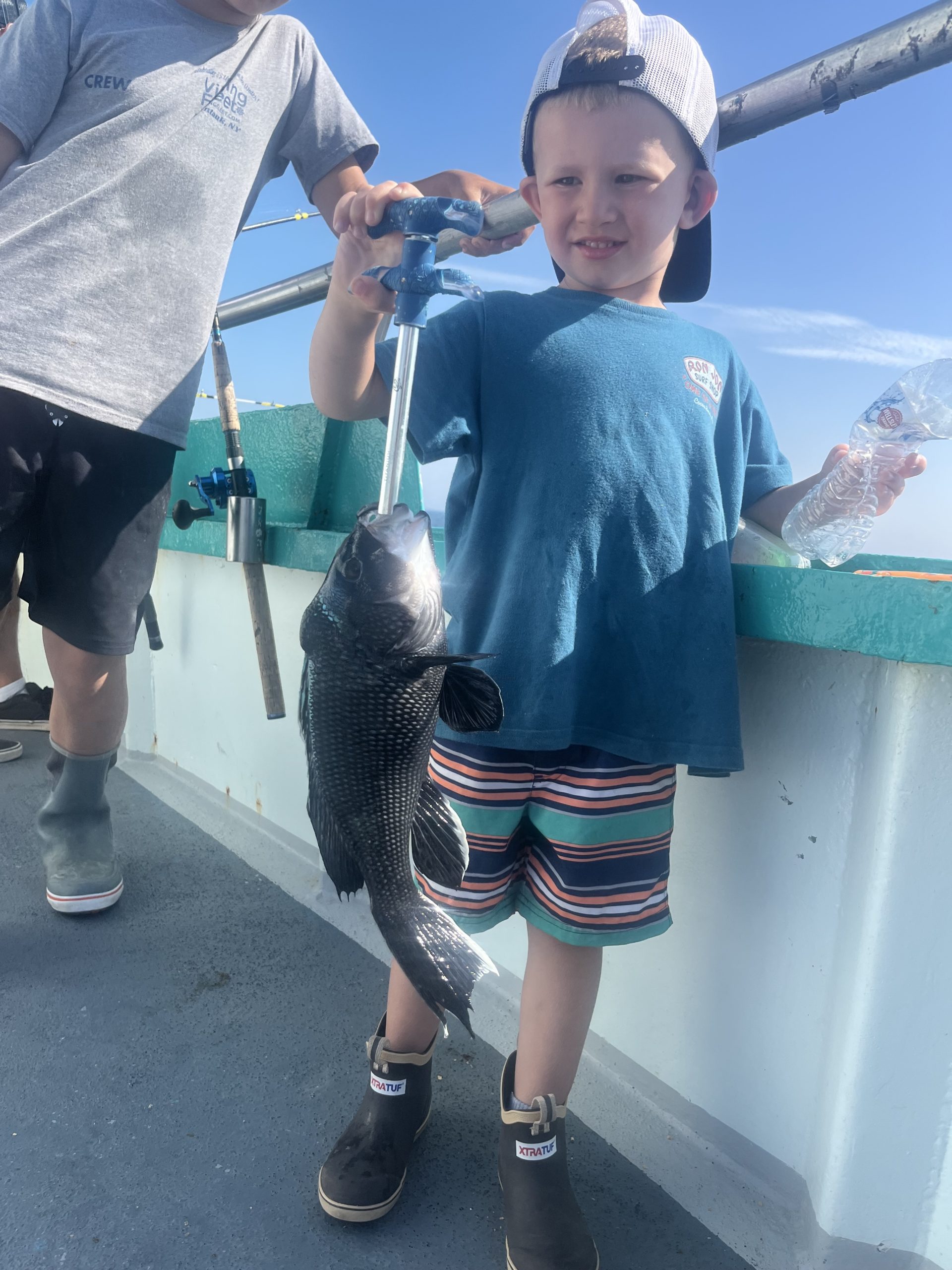 a young boy standing next to a statue