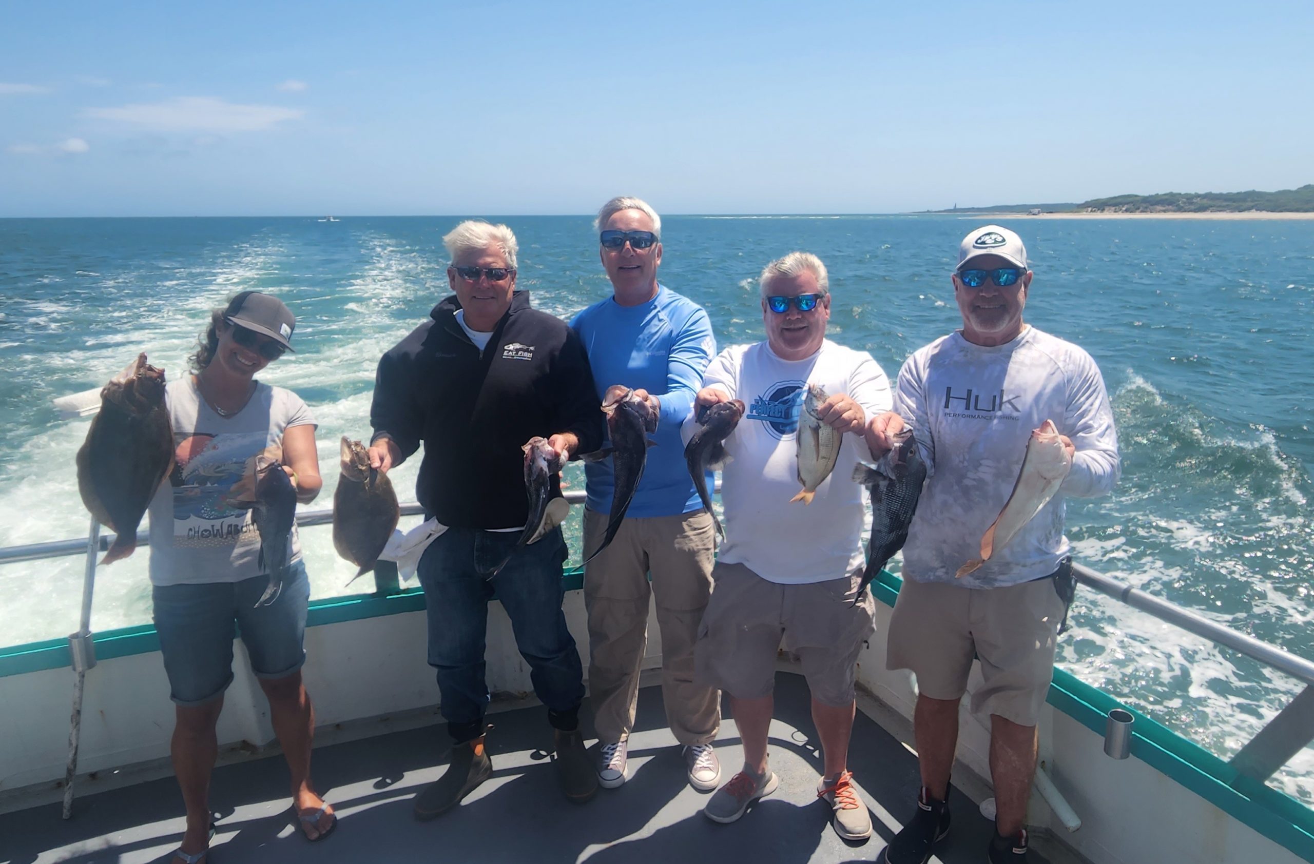 a group of people standing next to a body of water