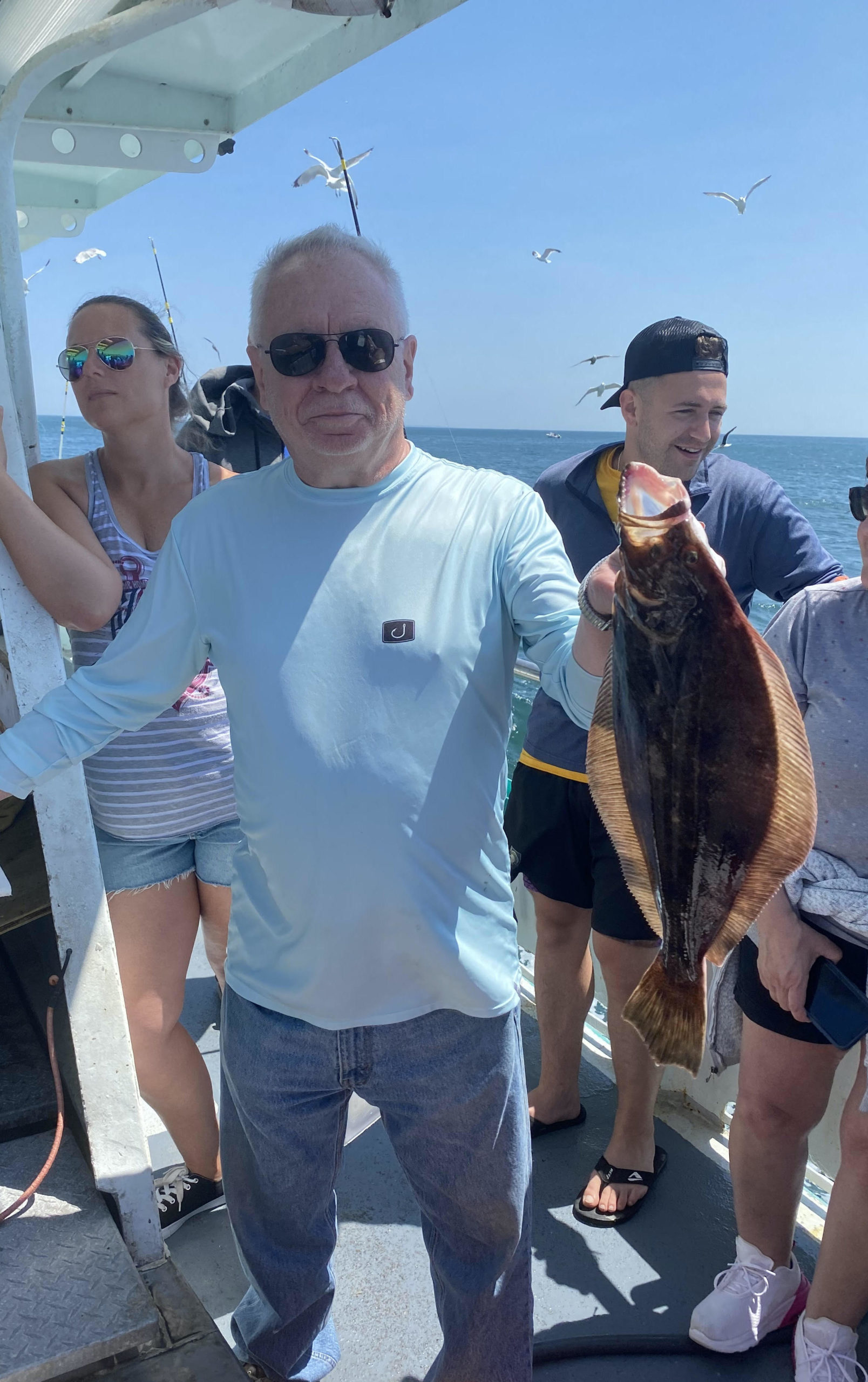 a group of people standing next to a person holding a fish
