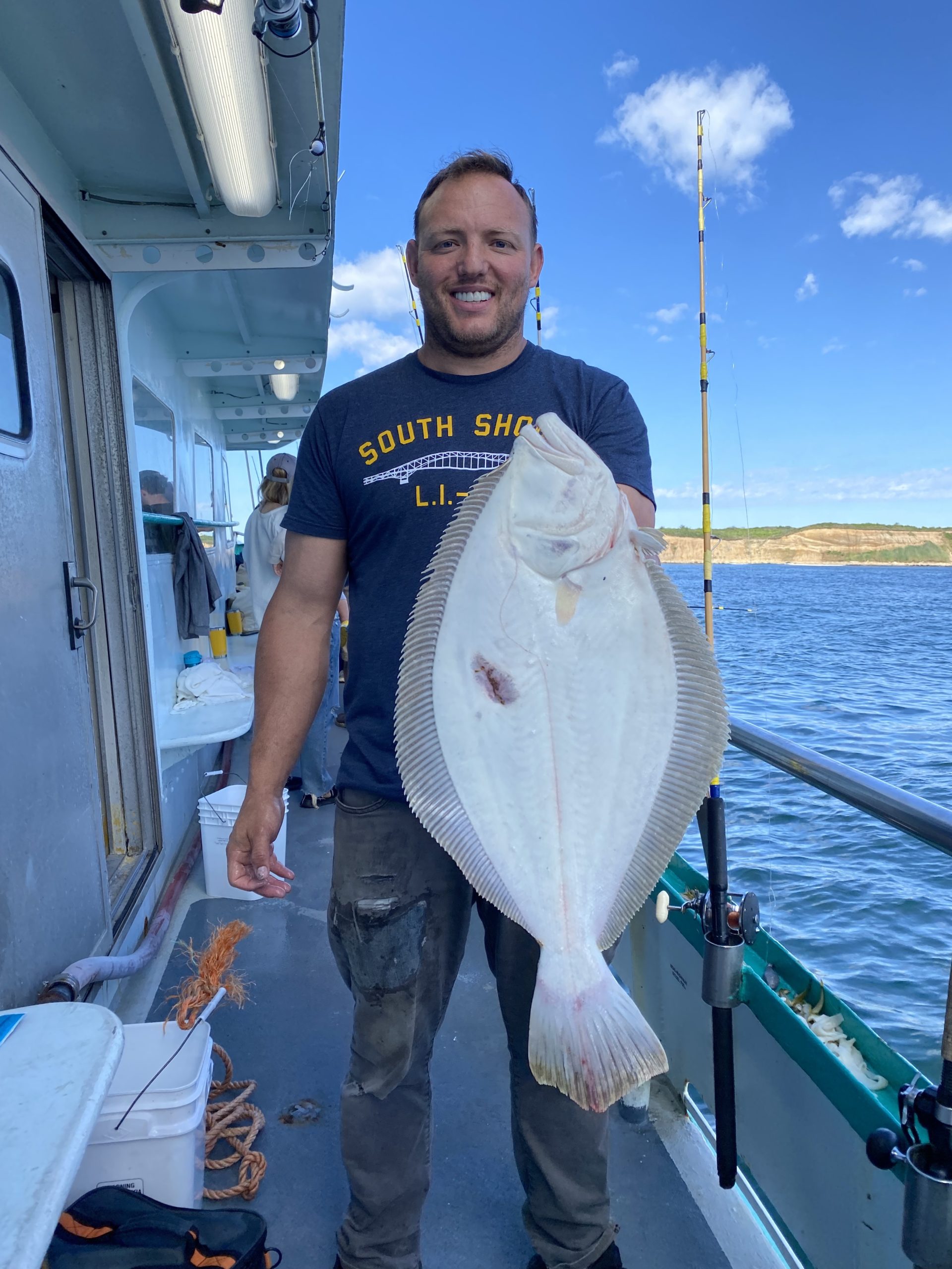 a man holding a fish on a boat