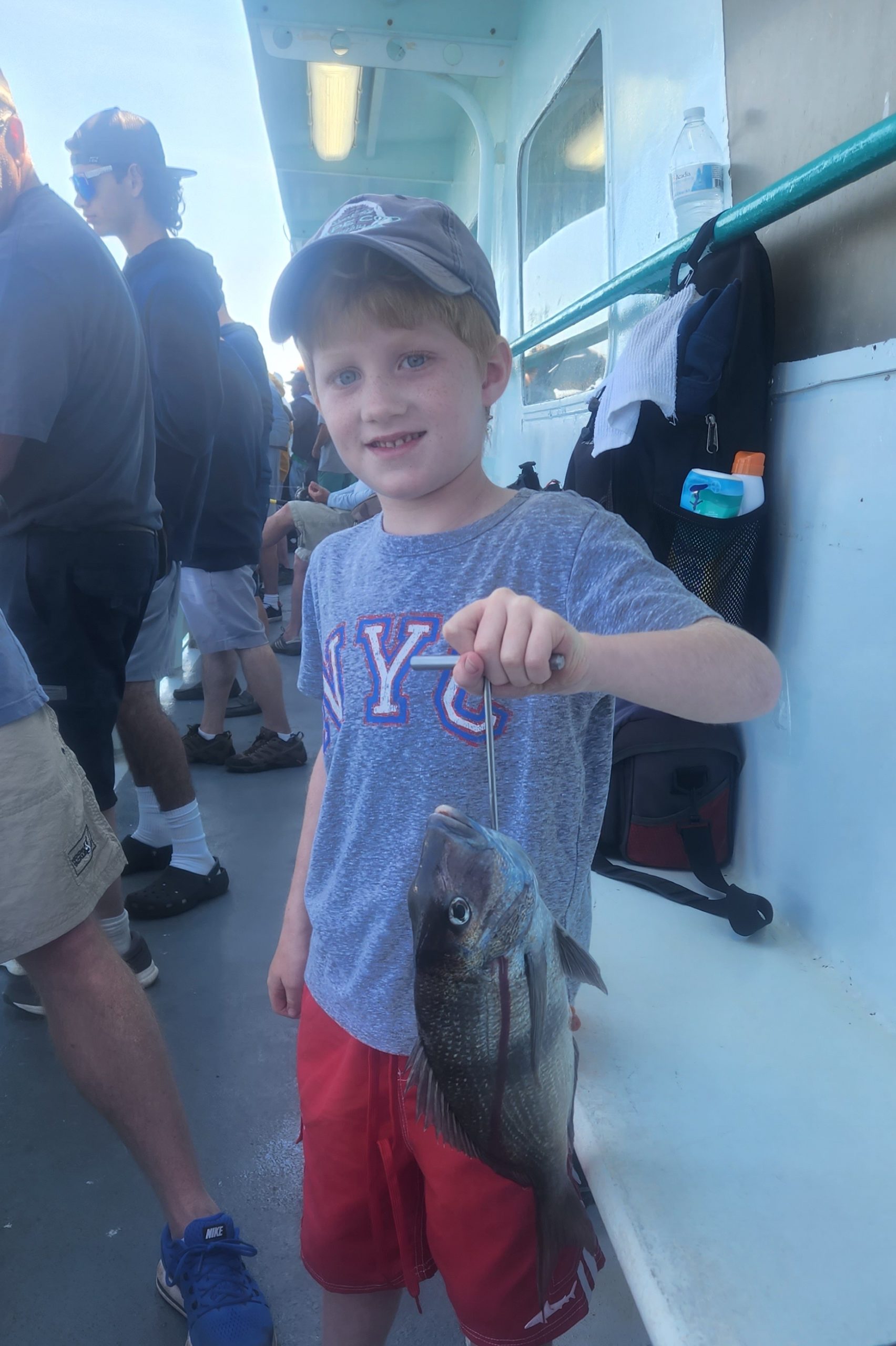 a little girl standing in front of a fish