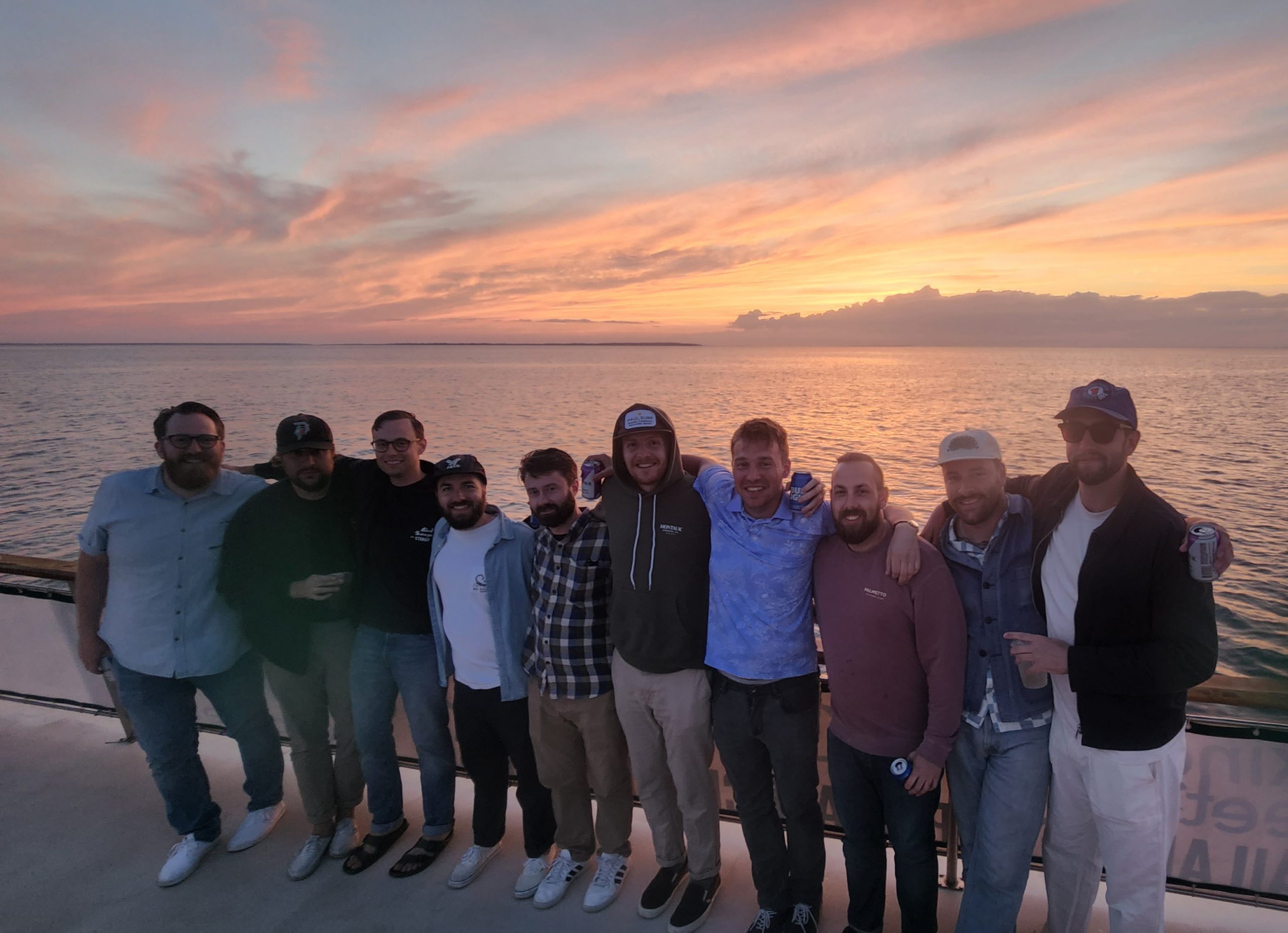 a group of people standing on a beach posing for the camera