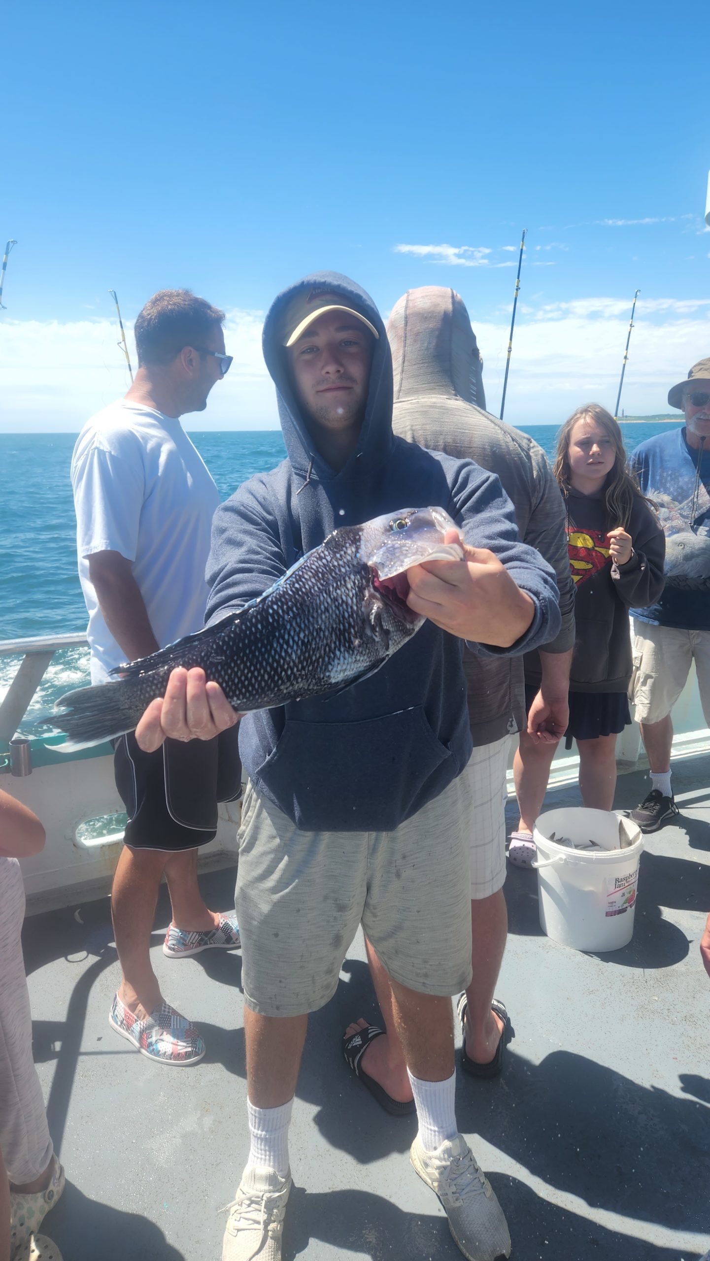 a group of people standing next to a person holding a fish