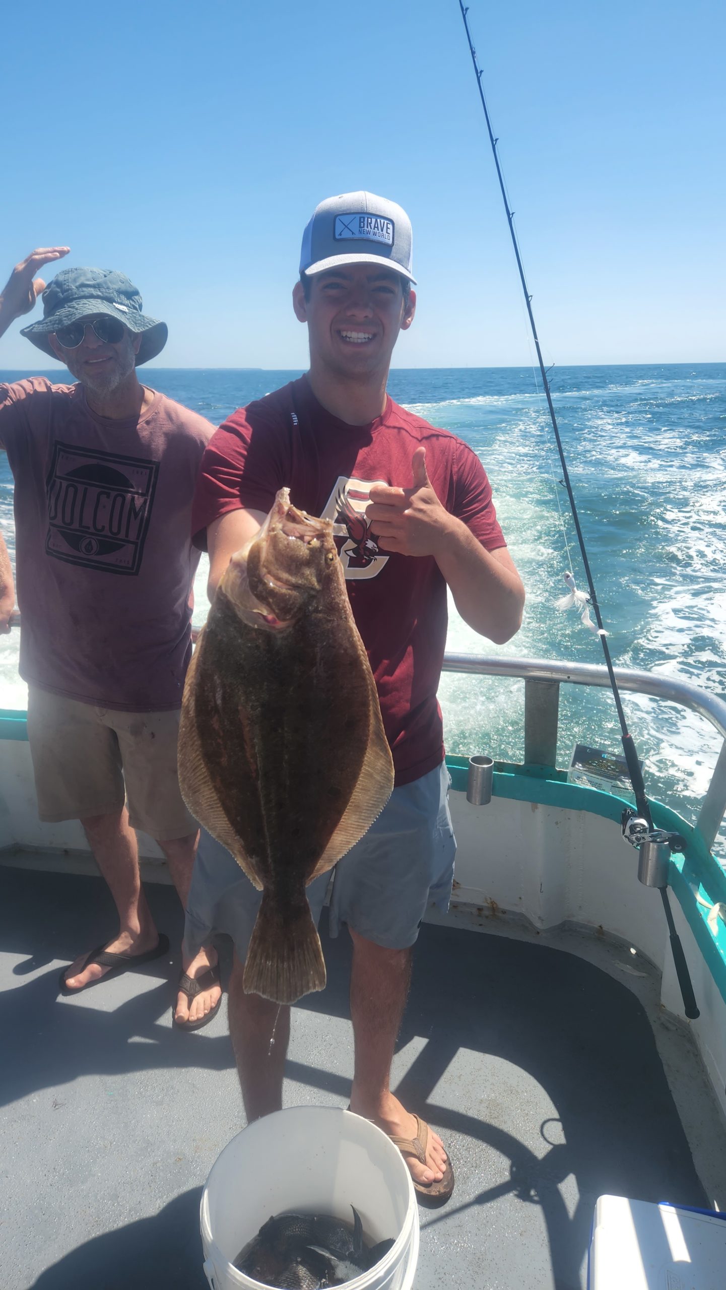 a man holding a fish on a boat in the water
