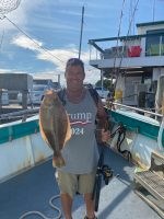 a man holding a fish on a boat