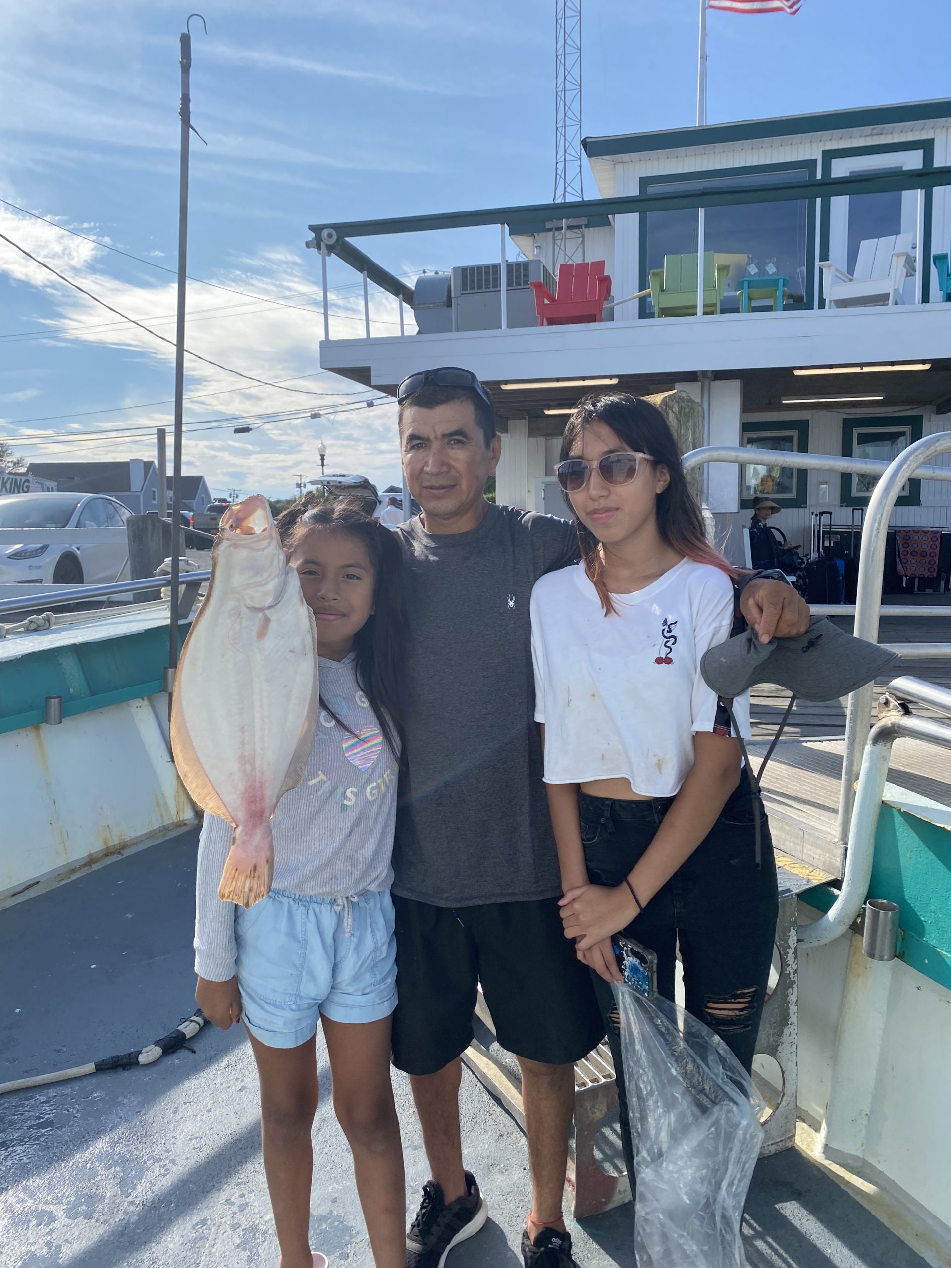 a man holding a fish on a boat posing for the camera