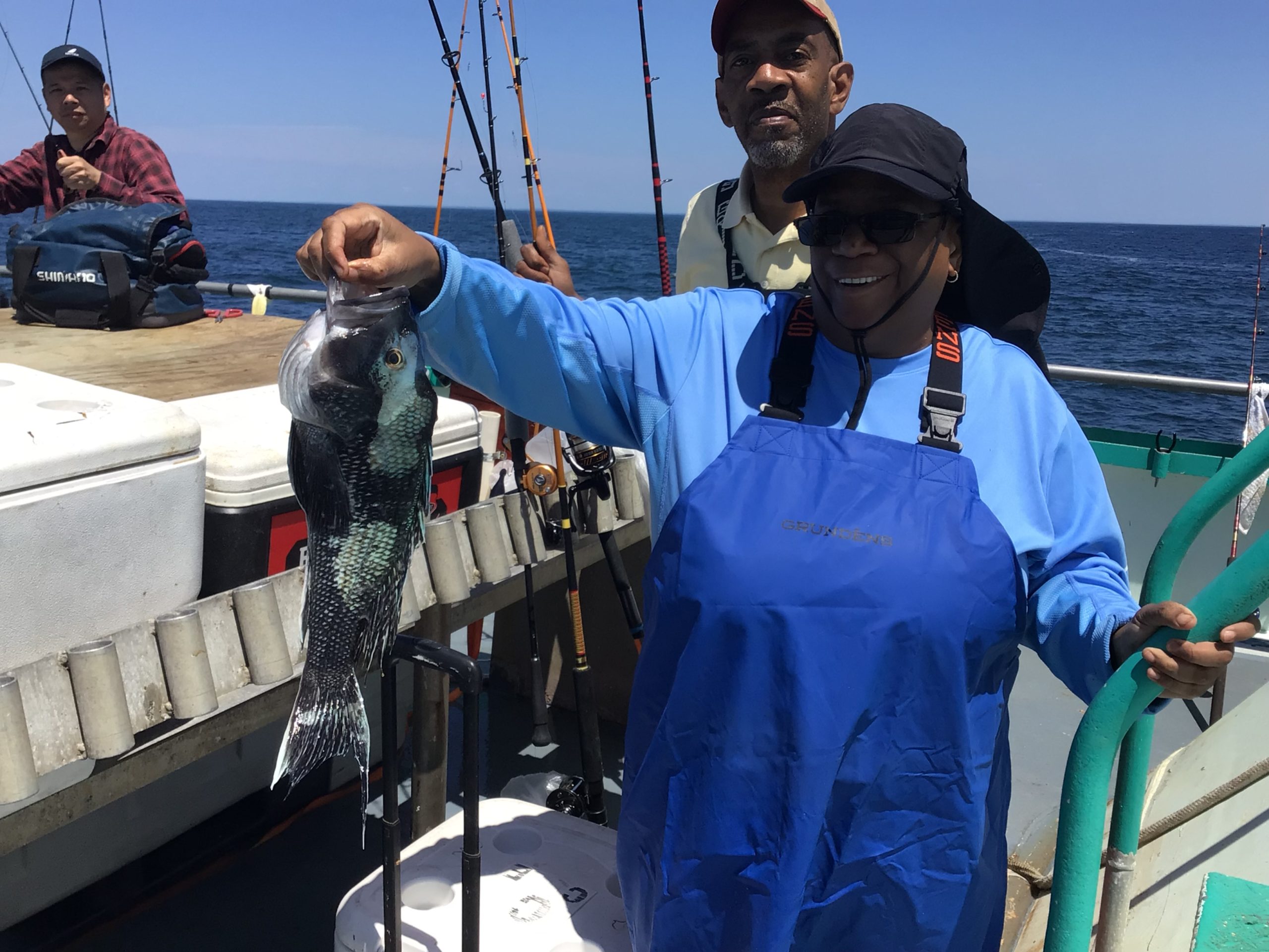 Ted Cam Jr standing next to a boat