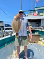 a man holding a fish on a boat
