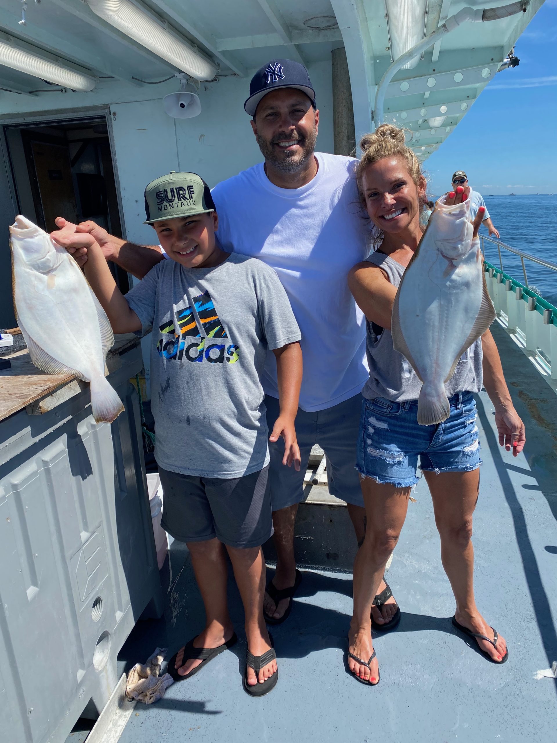 a group of people standing next to a person holding a fish