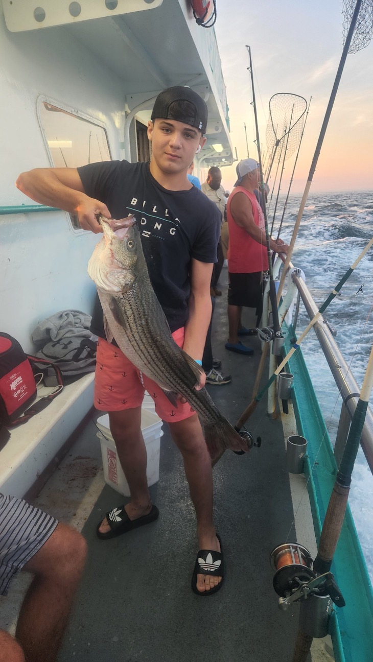 a man holding a fish on a boat