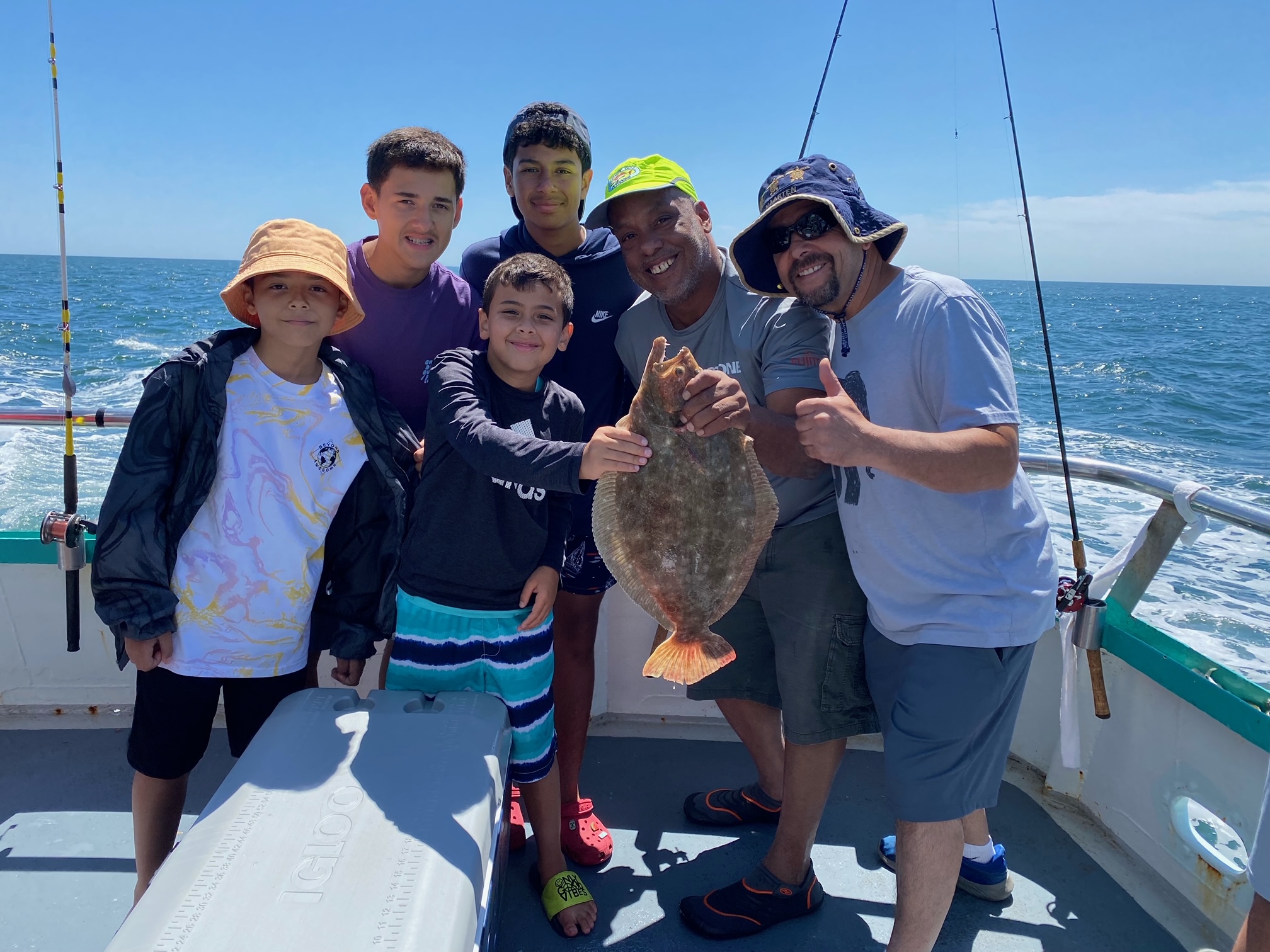 Drew Davis et al. standing next to a person holding a fish