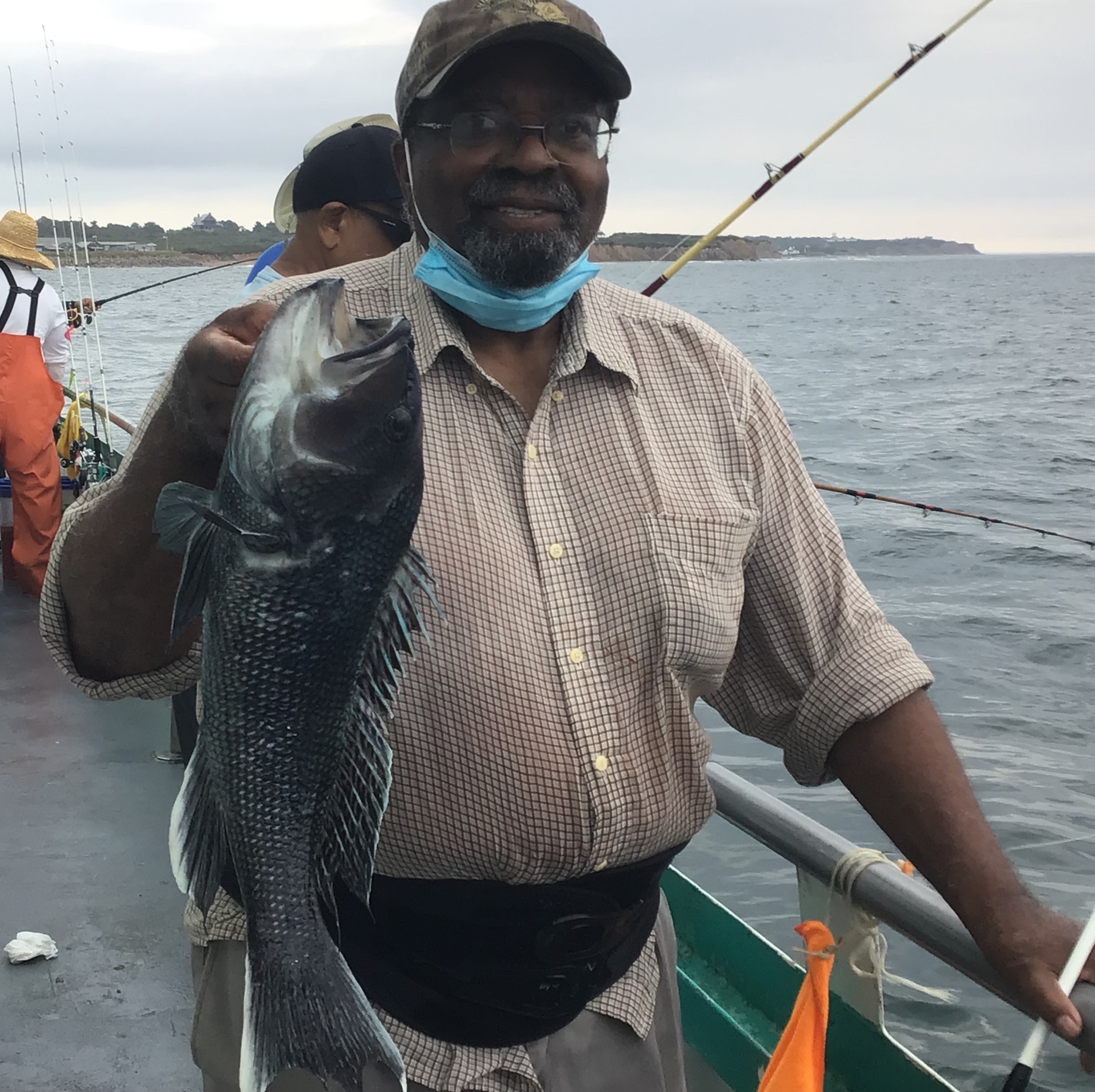 a man holding a fish on a boat in a body of water