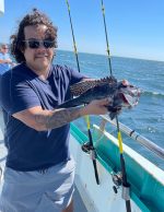 a man standing next to a body of water