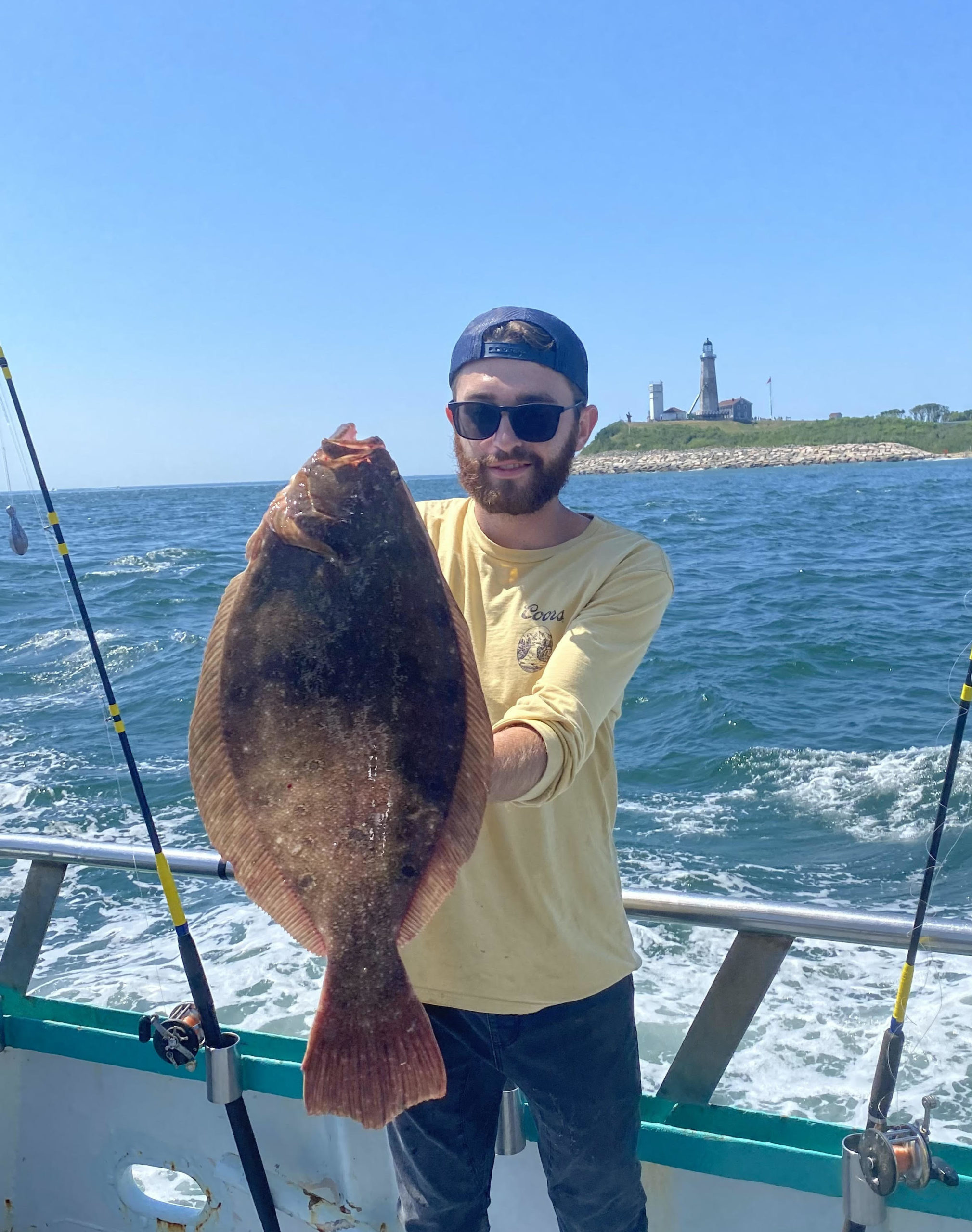 a man holding a fish on a boat in the water
