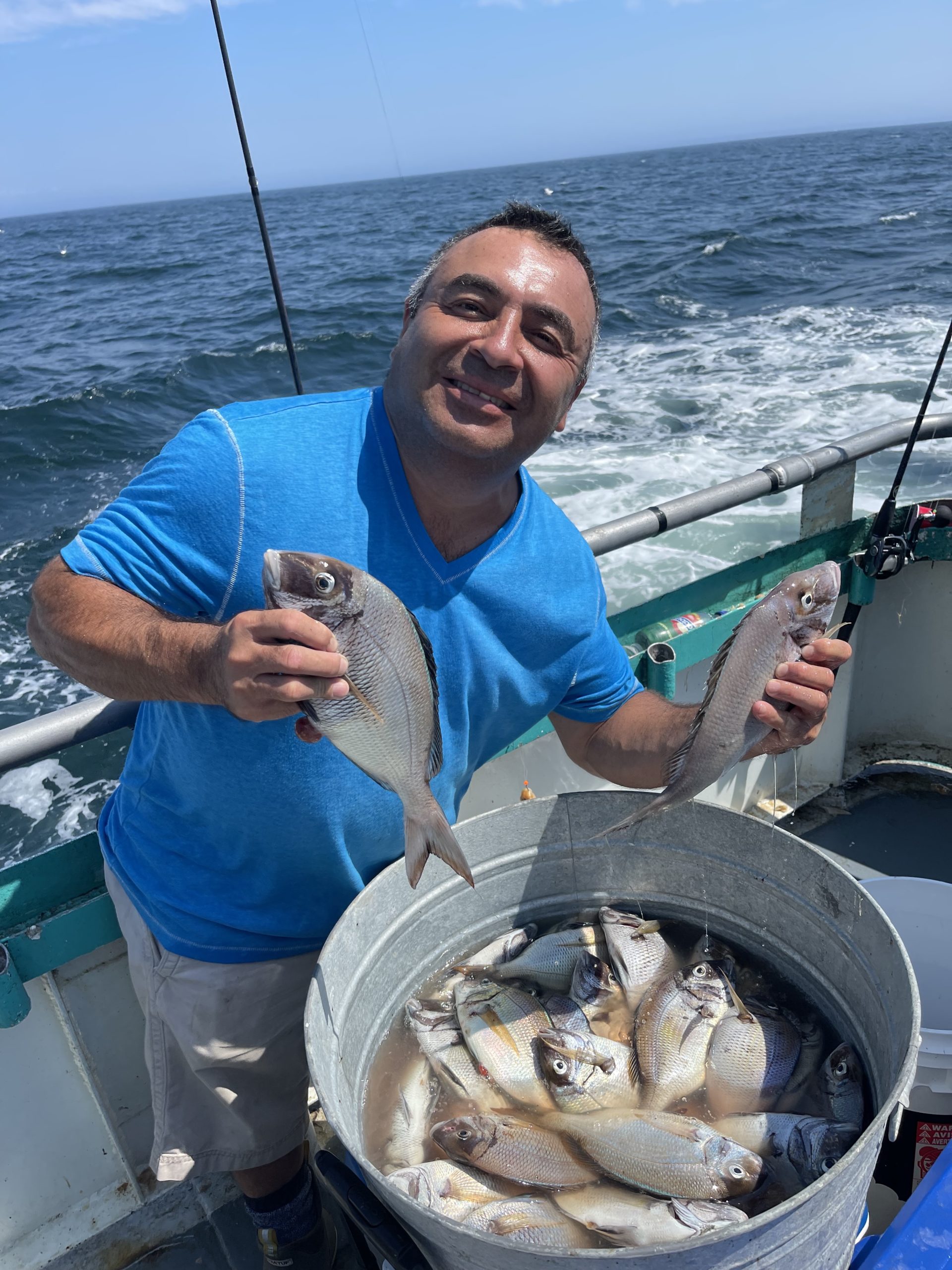 a person standing in front of a boat next to a body of water