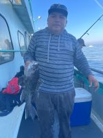 a man holding a fish on a boat