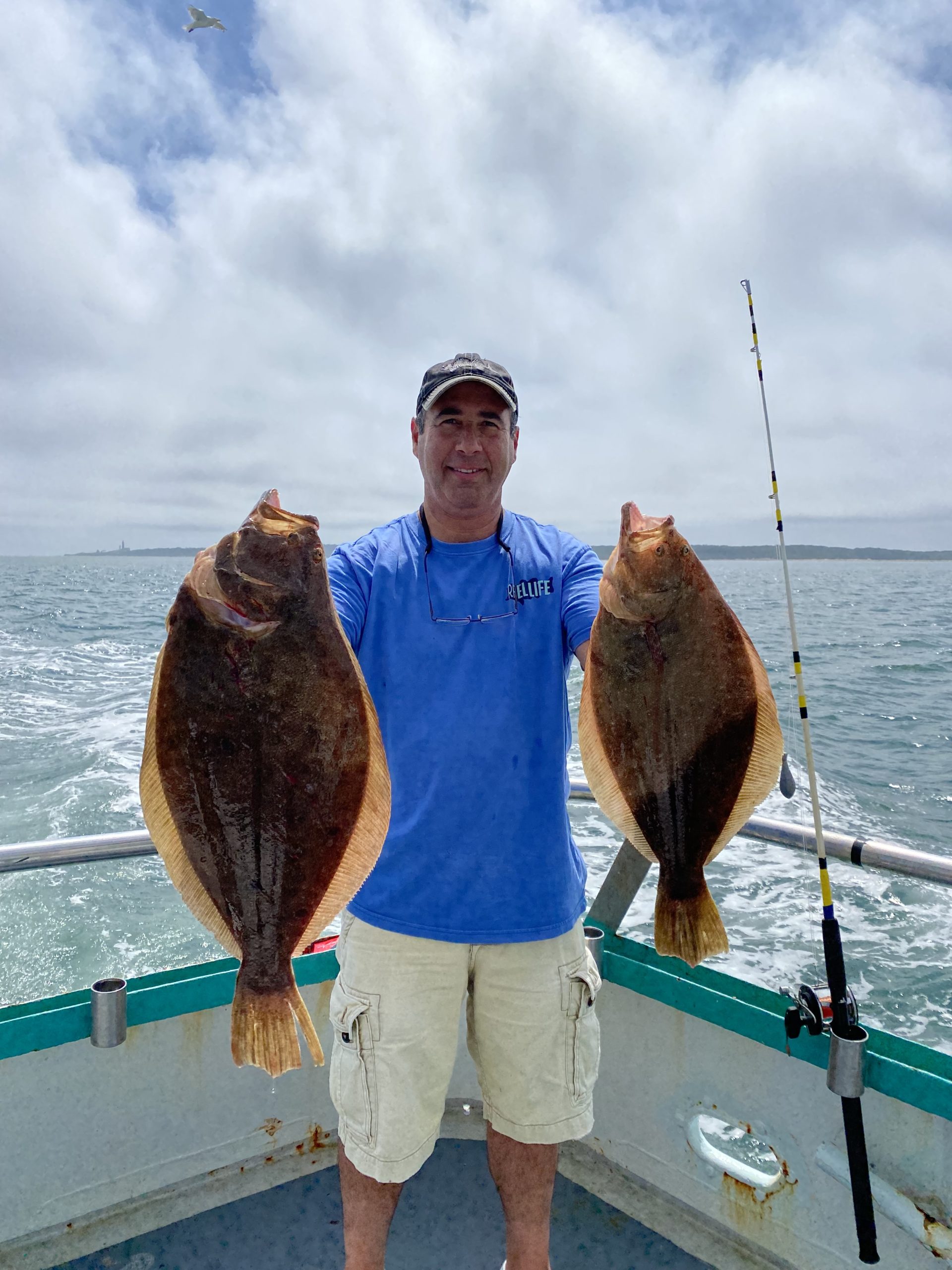 a man holding a fish on a boat in the water