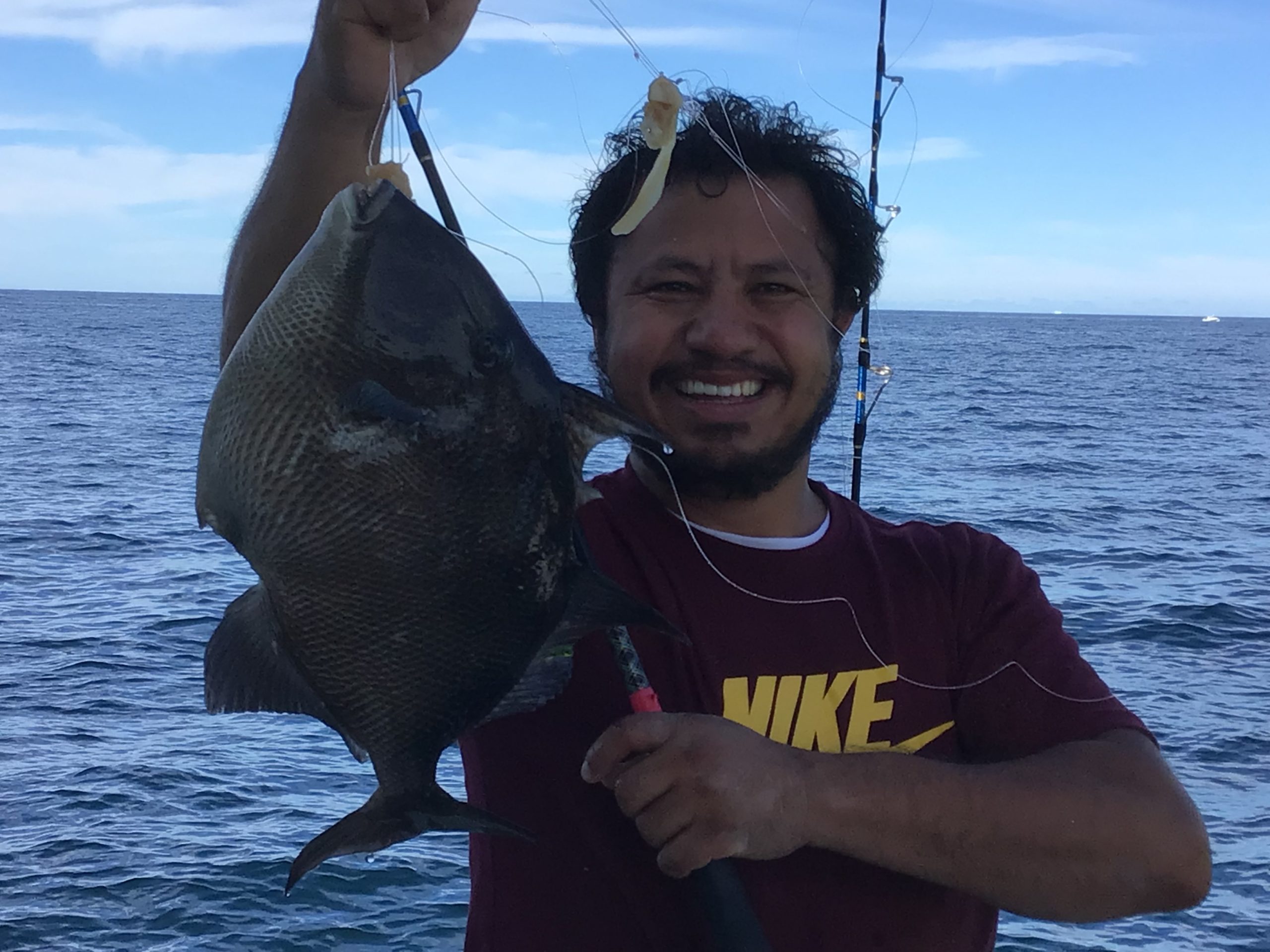 a person holding a fish on a boat in a body of water