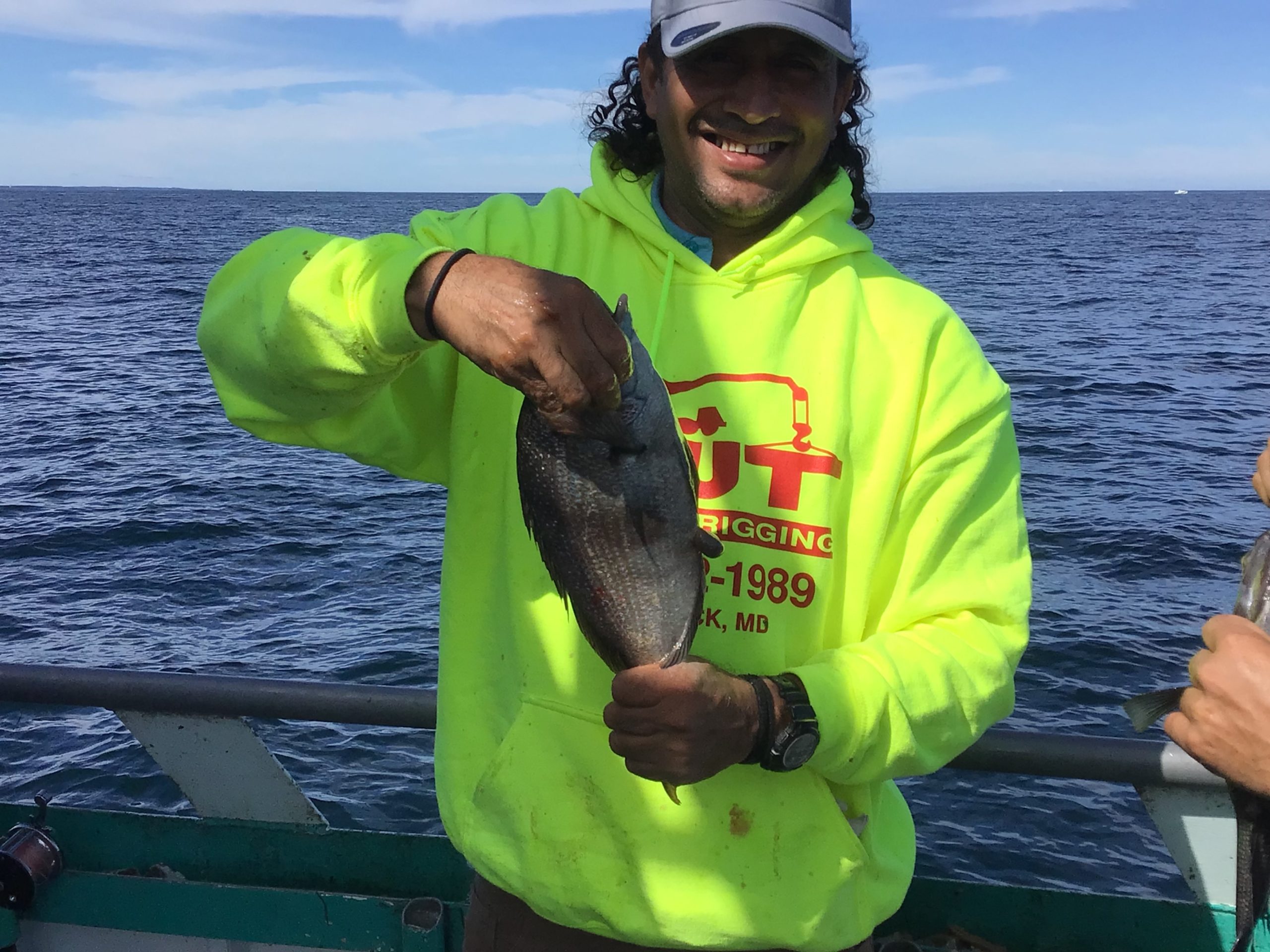 a smiling man in a green boat on a body of water