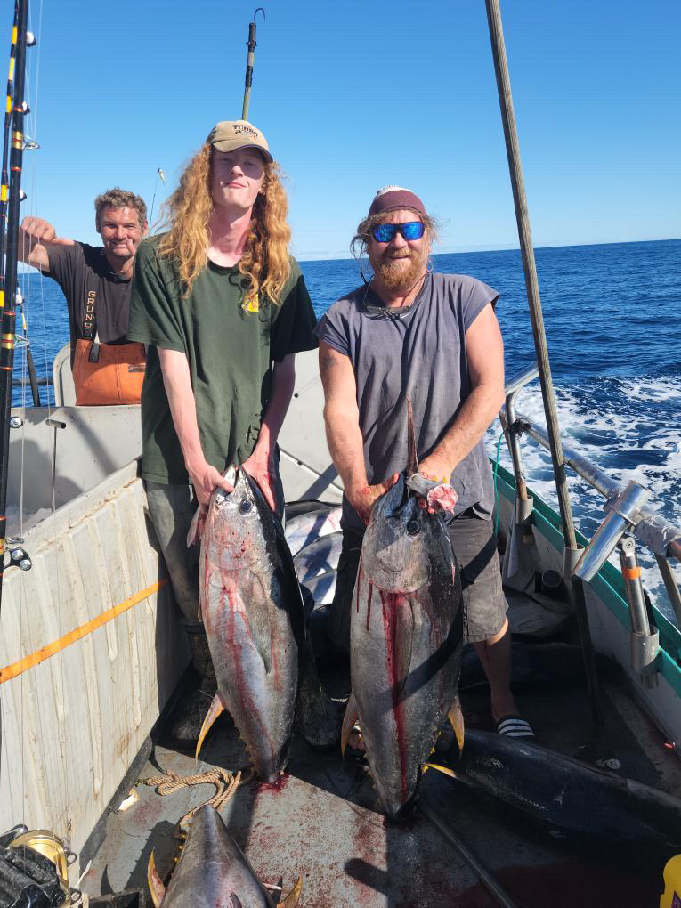 a man holding a fish on a boat