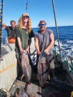 a man holding a fish on a boat