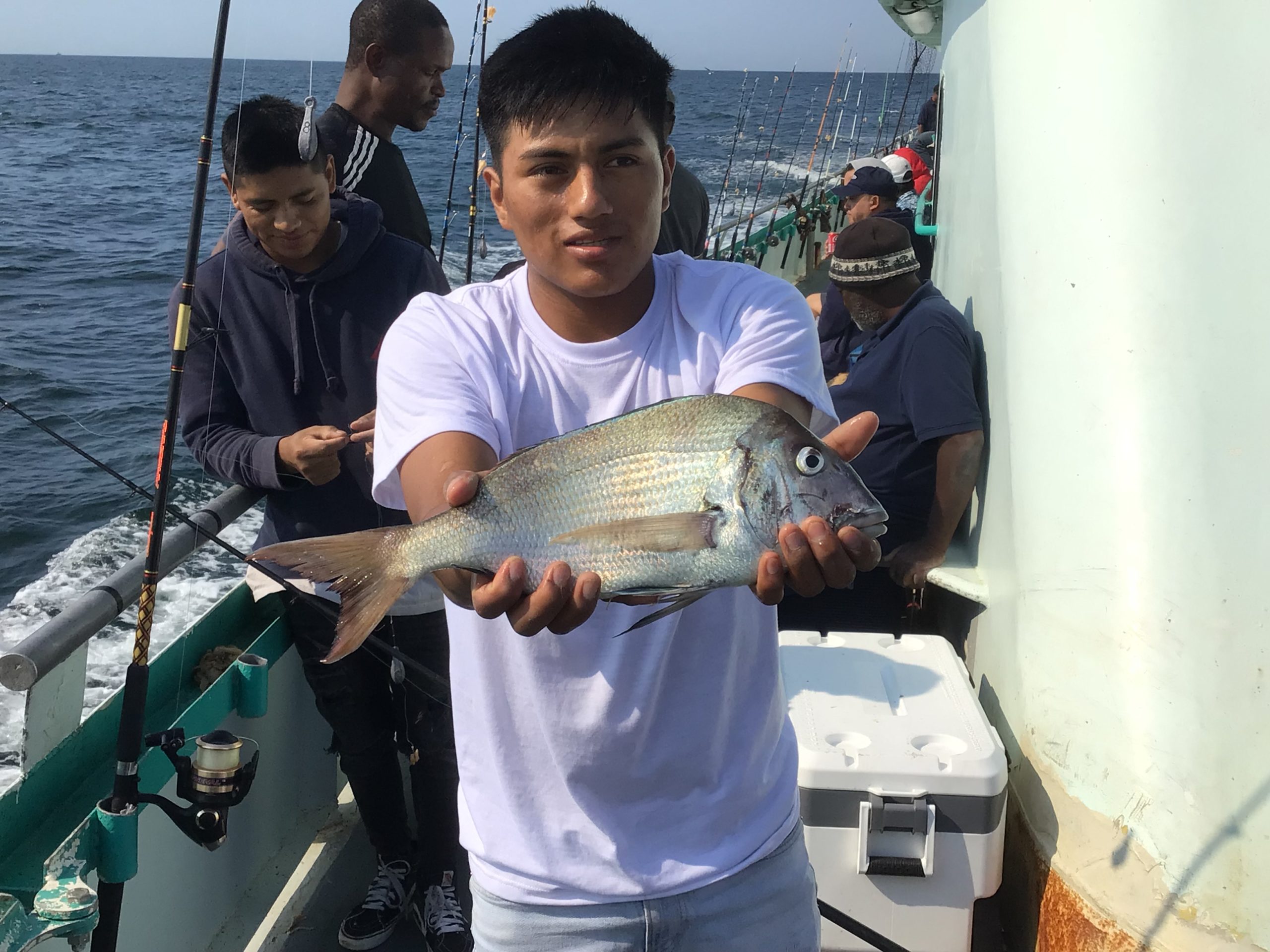 a man holding a fish on a boat