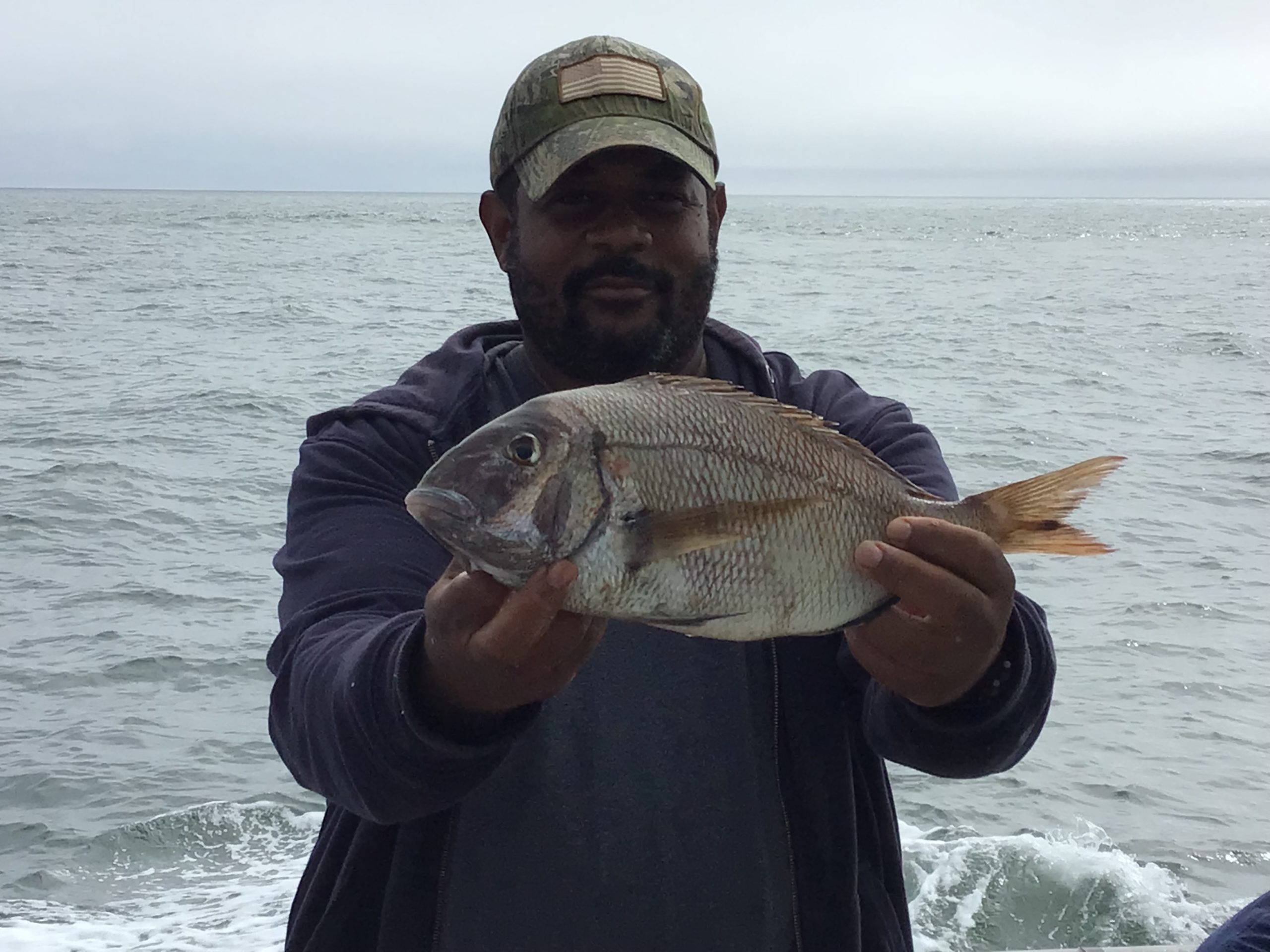 a man holding a fish in the water