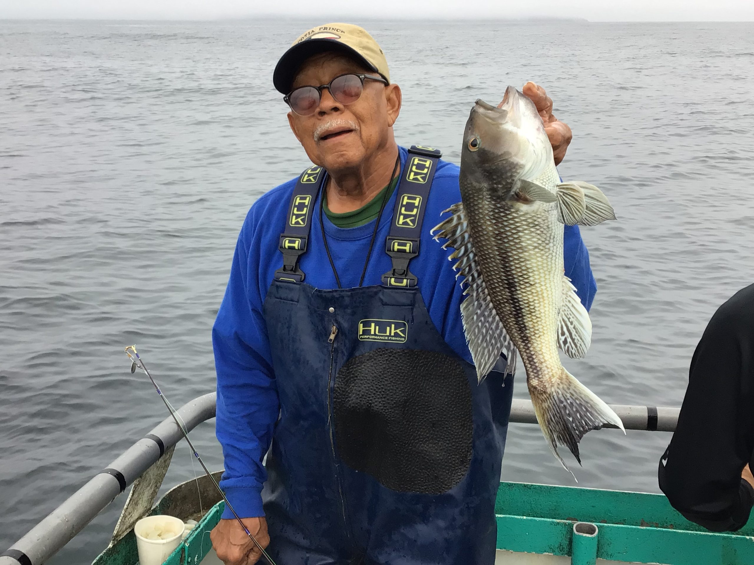 a person holding a fish on a boat in a body of water