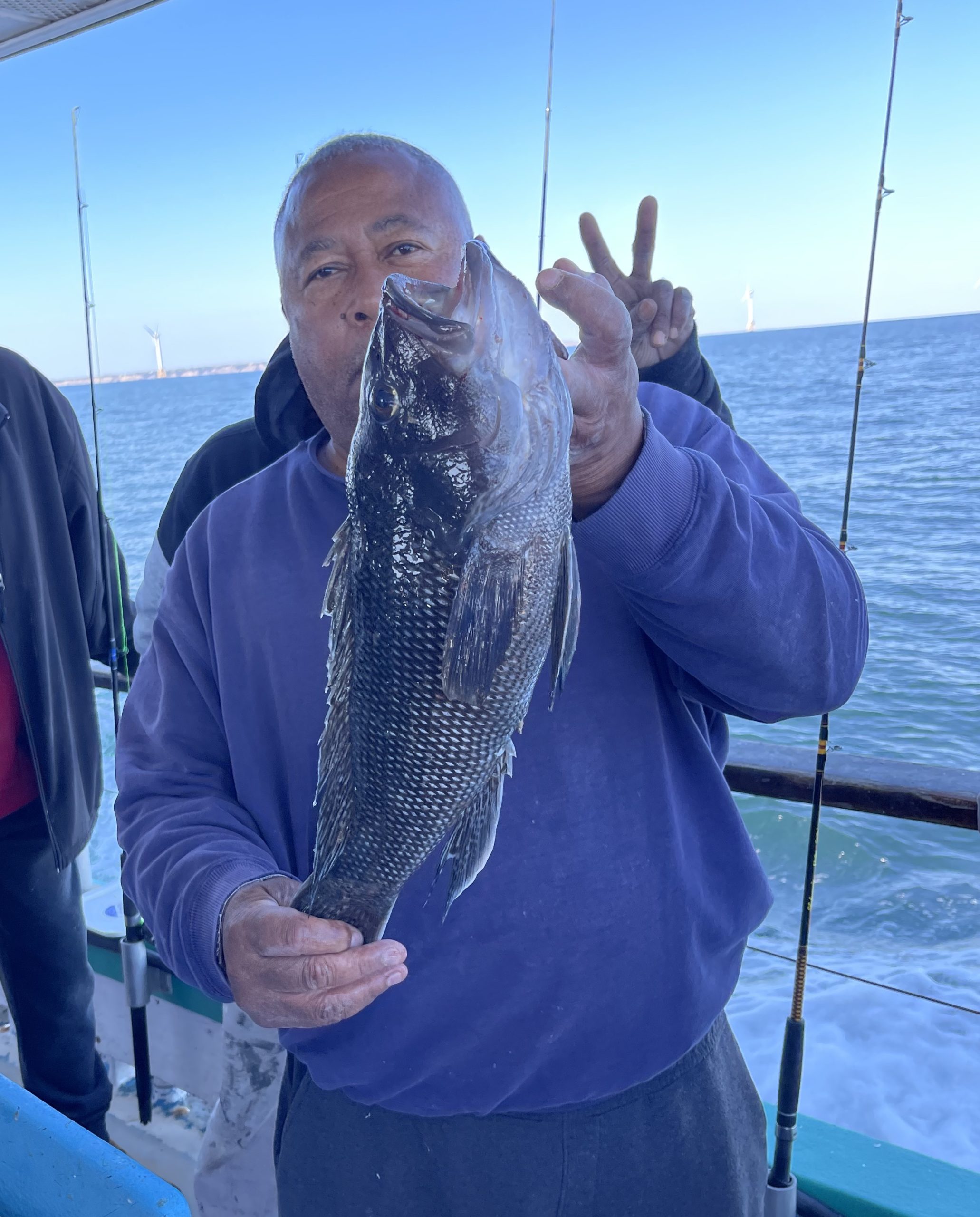 a person holding a fish on a boat in a body of water