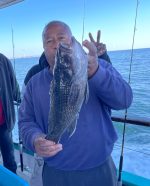 a person holding a fish on a boat in a body of water