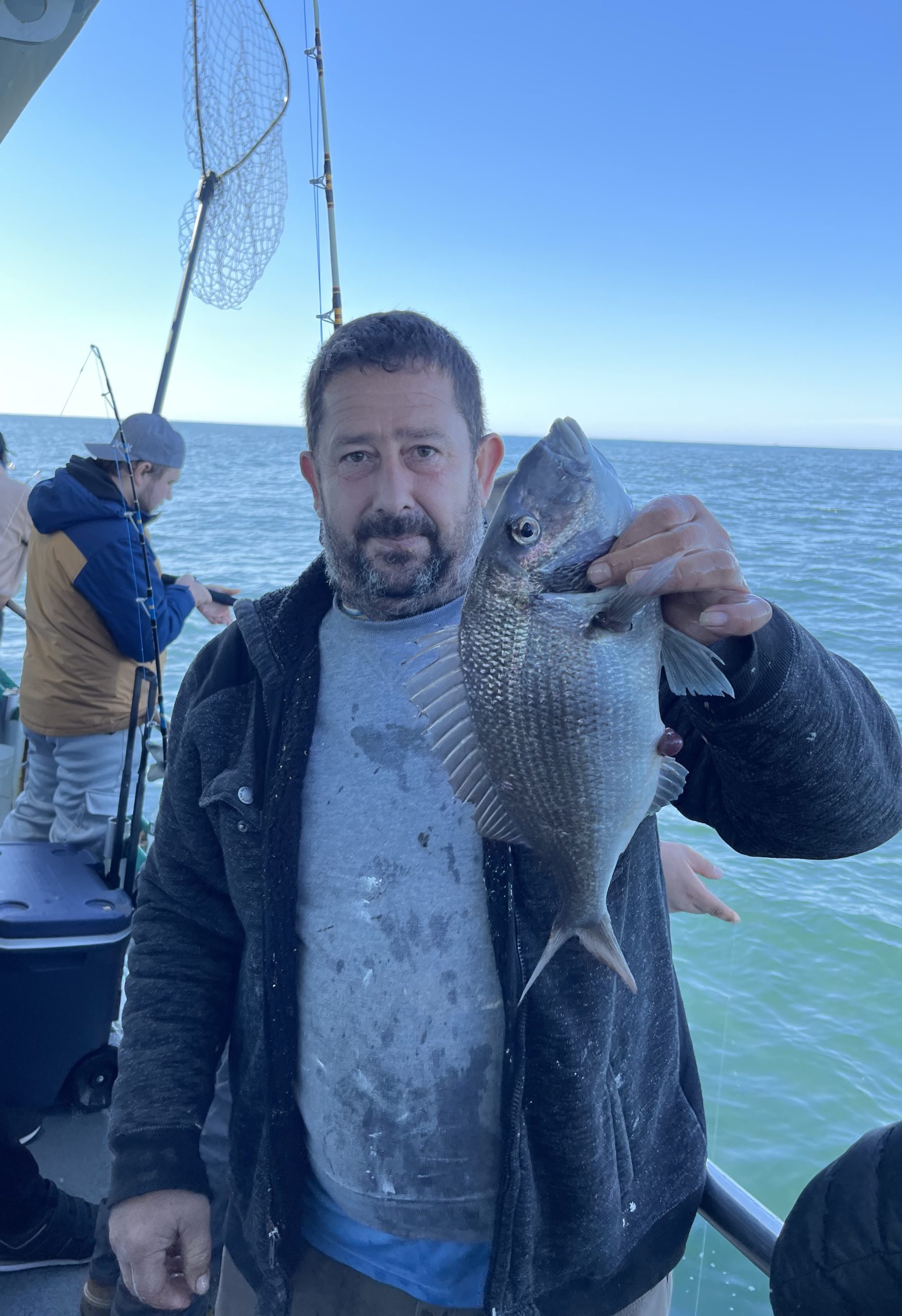 a person holding a fish on a boat in a body of water
