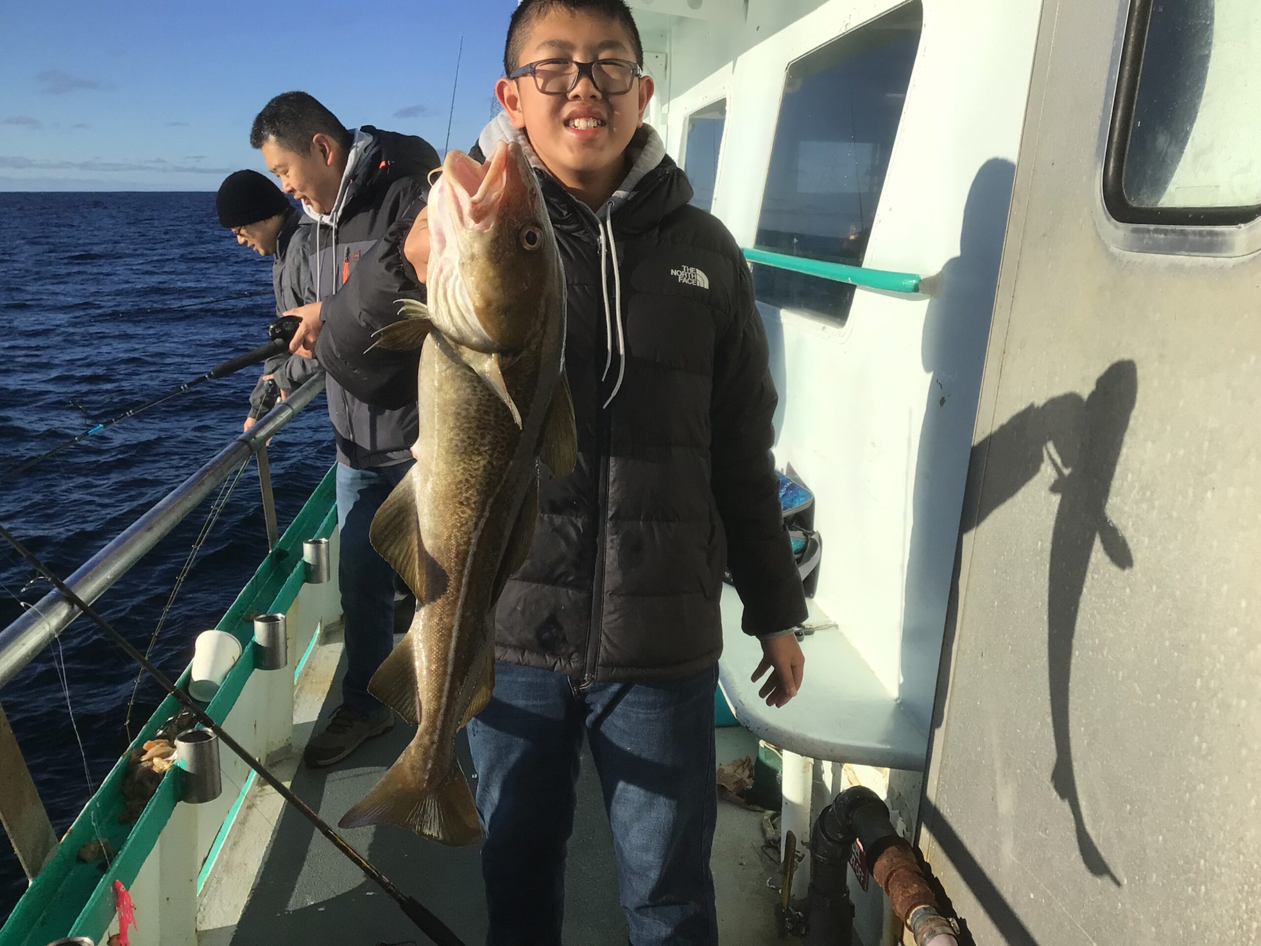 a man holding a fish on a boat