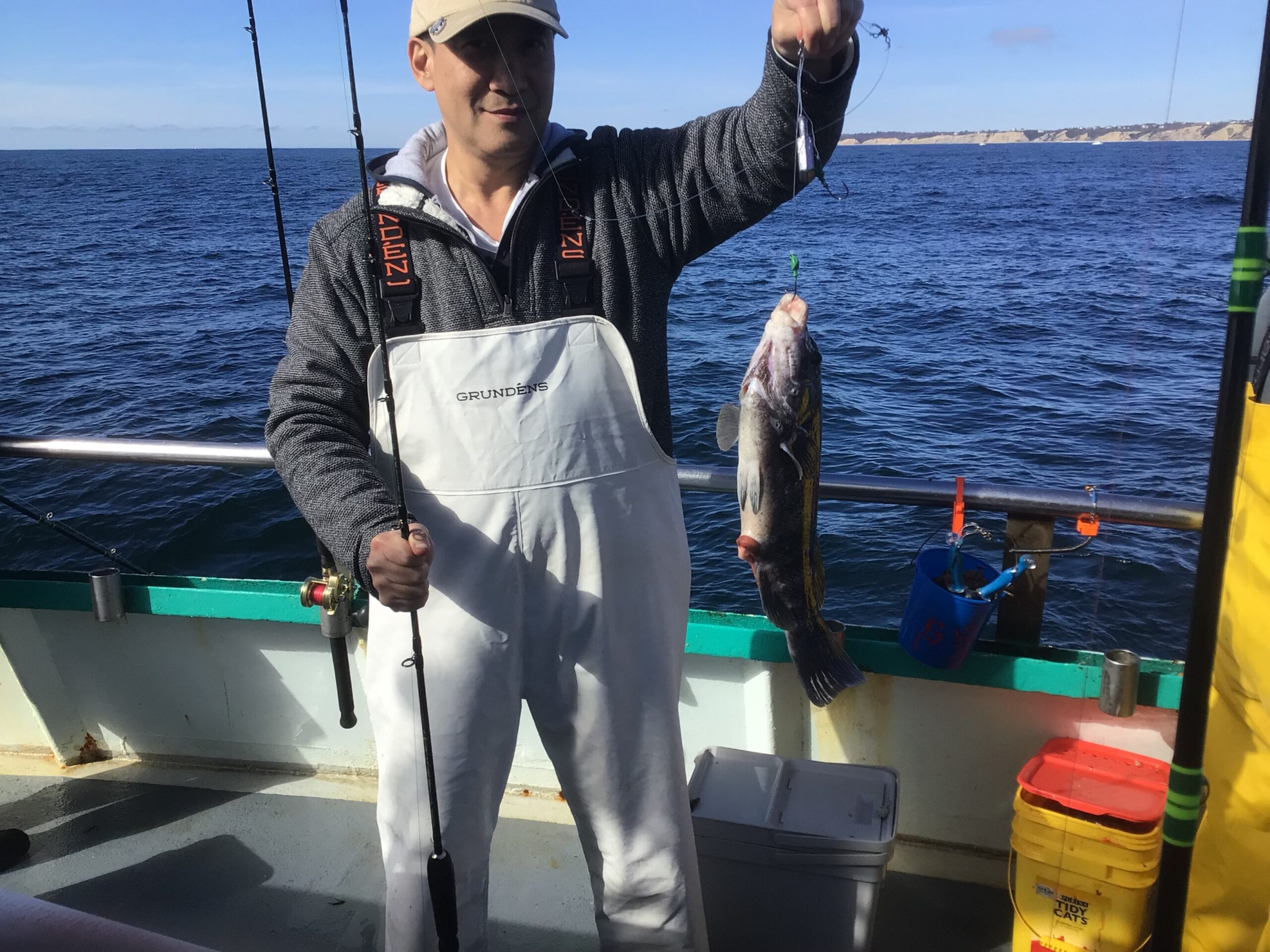 a man holding a fish on a boat in the water