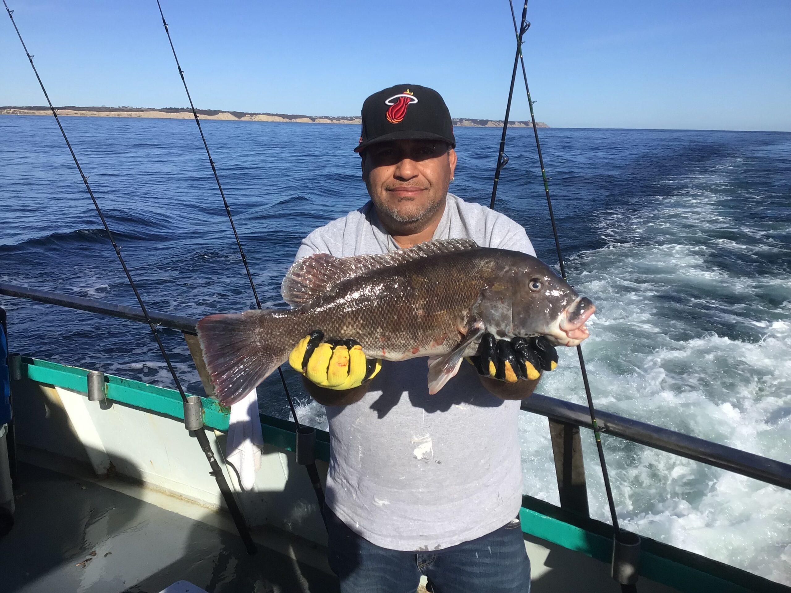 a man holding a fish on a boat in the water
