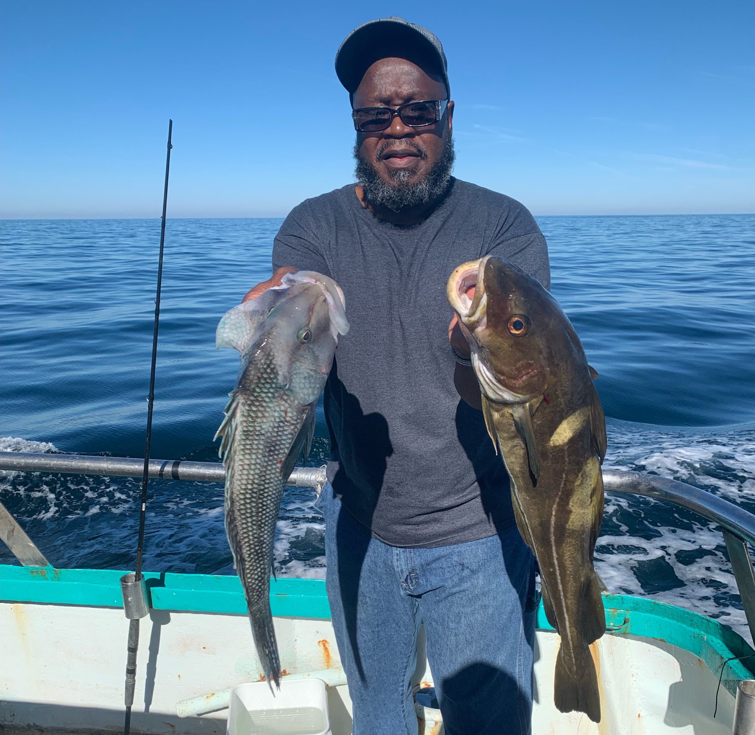 a man holding a fish on a boat in a body of water