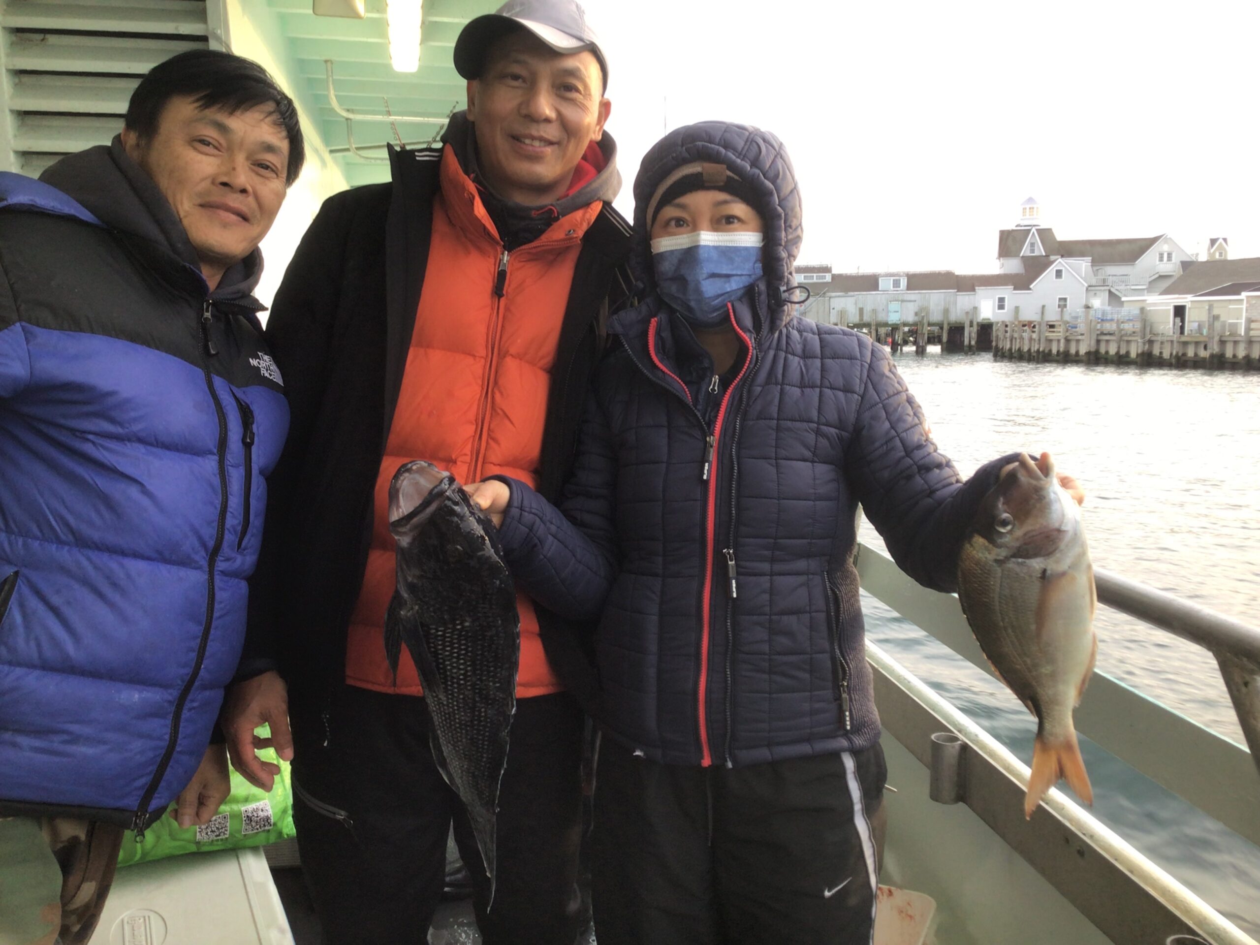 a group of people standing next to a person holding a fish