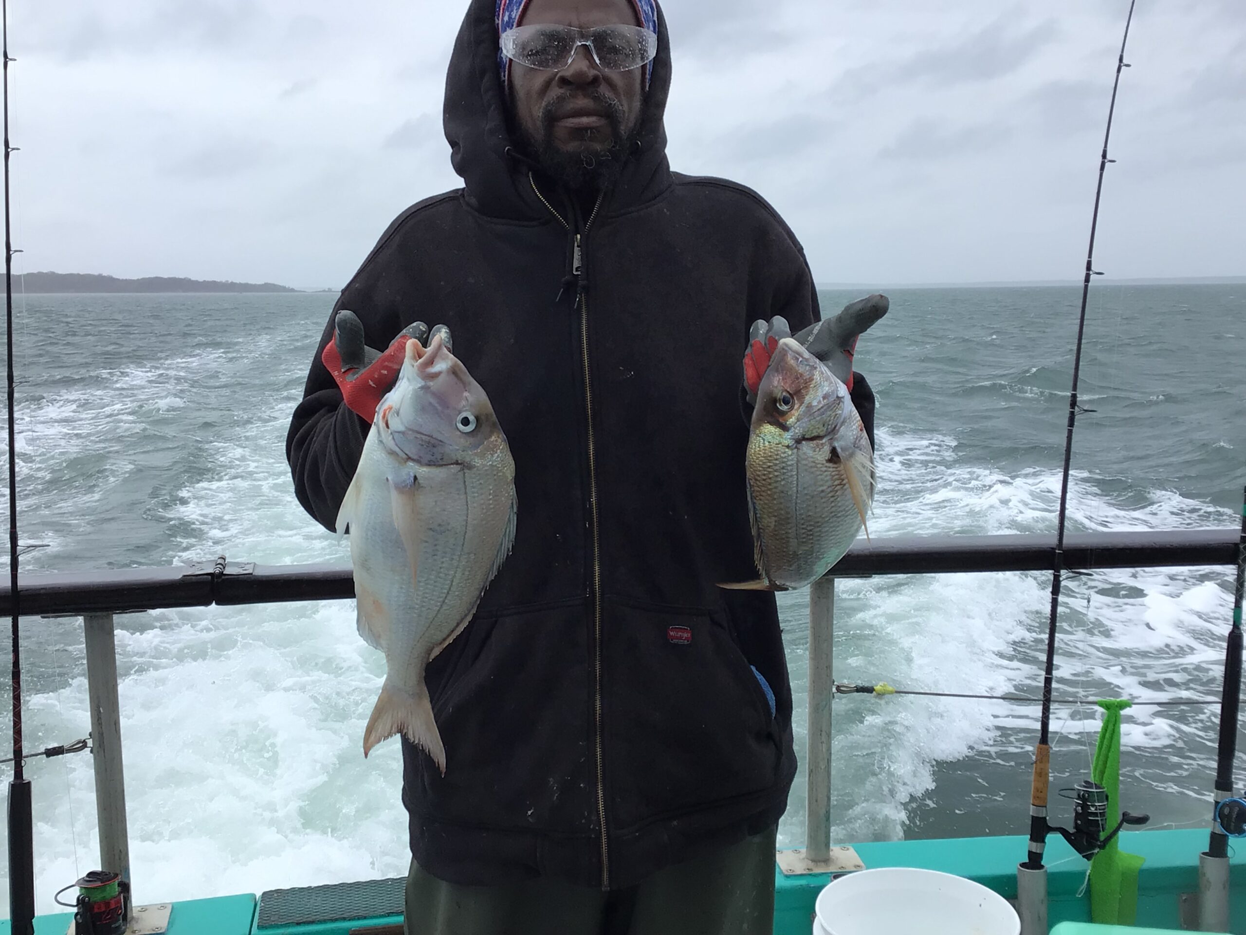 a person holding a fish on a boat in a body of water