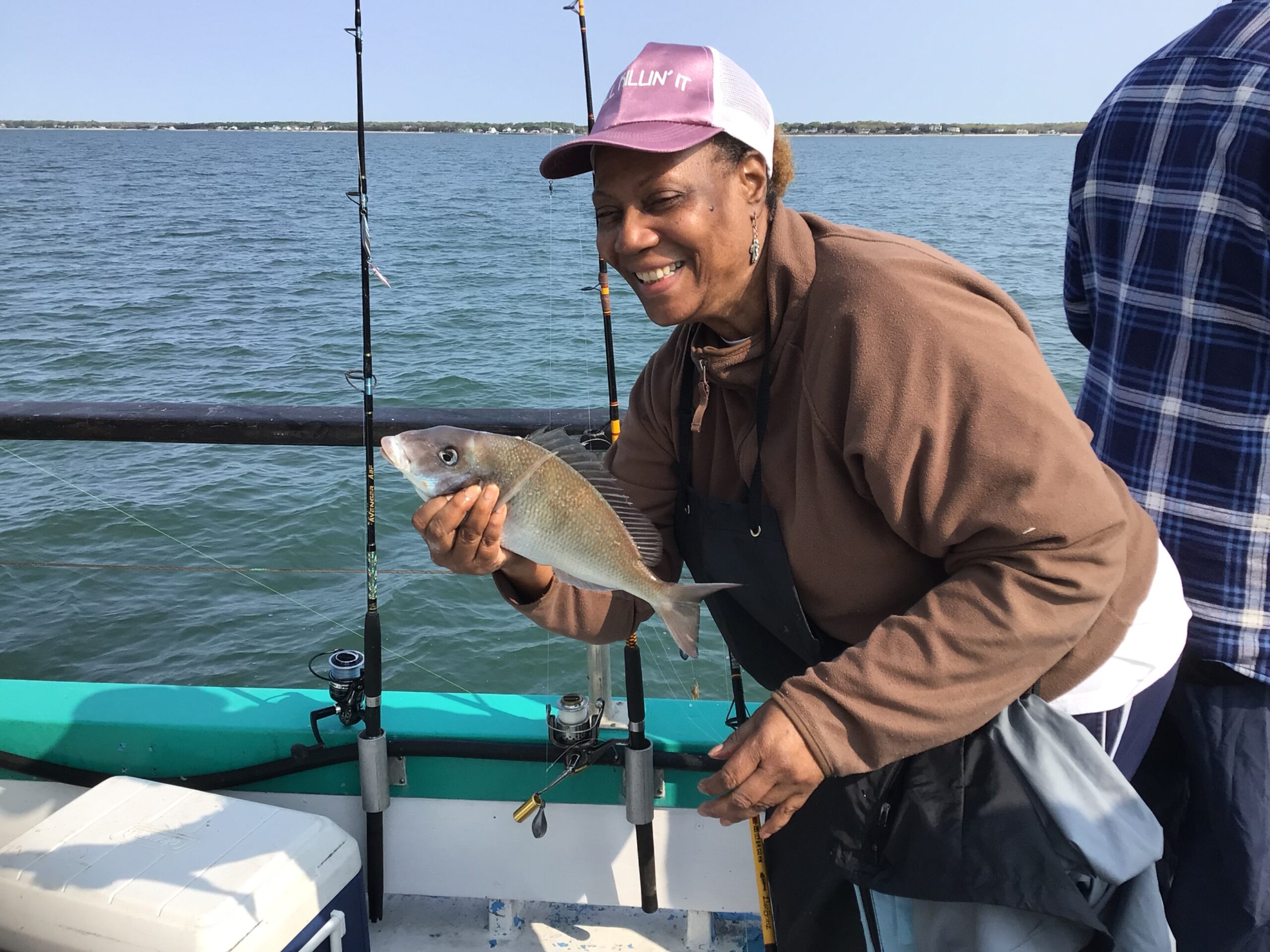 a man holding a fish on a boat in the water