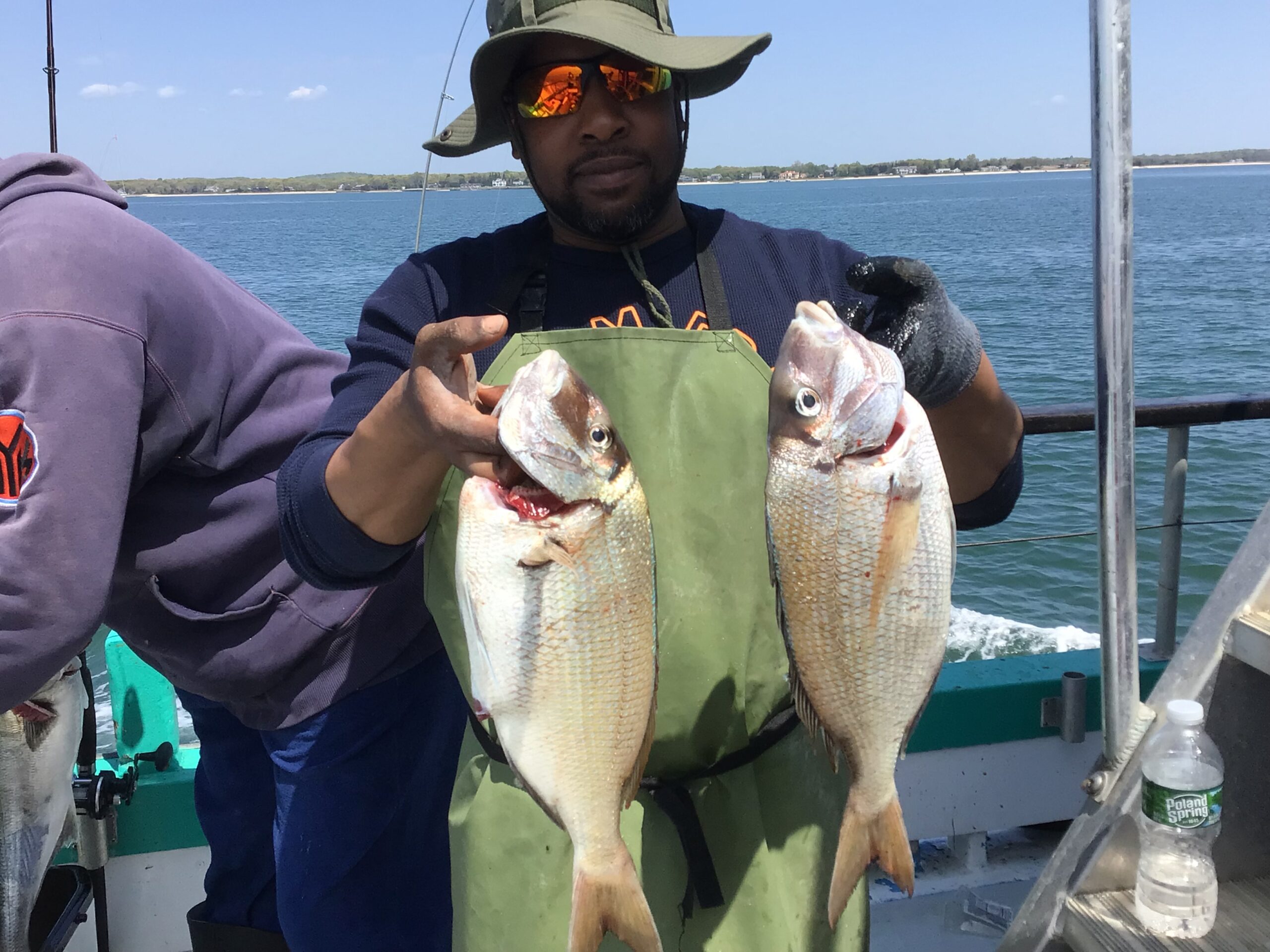 a person holding a fish on a boat in a body of water