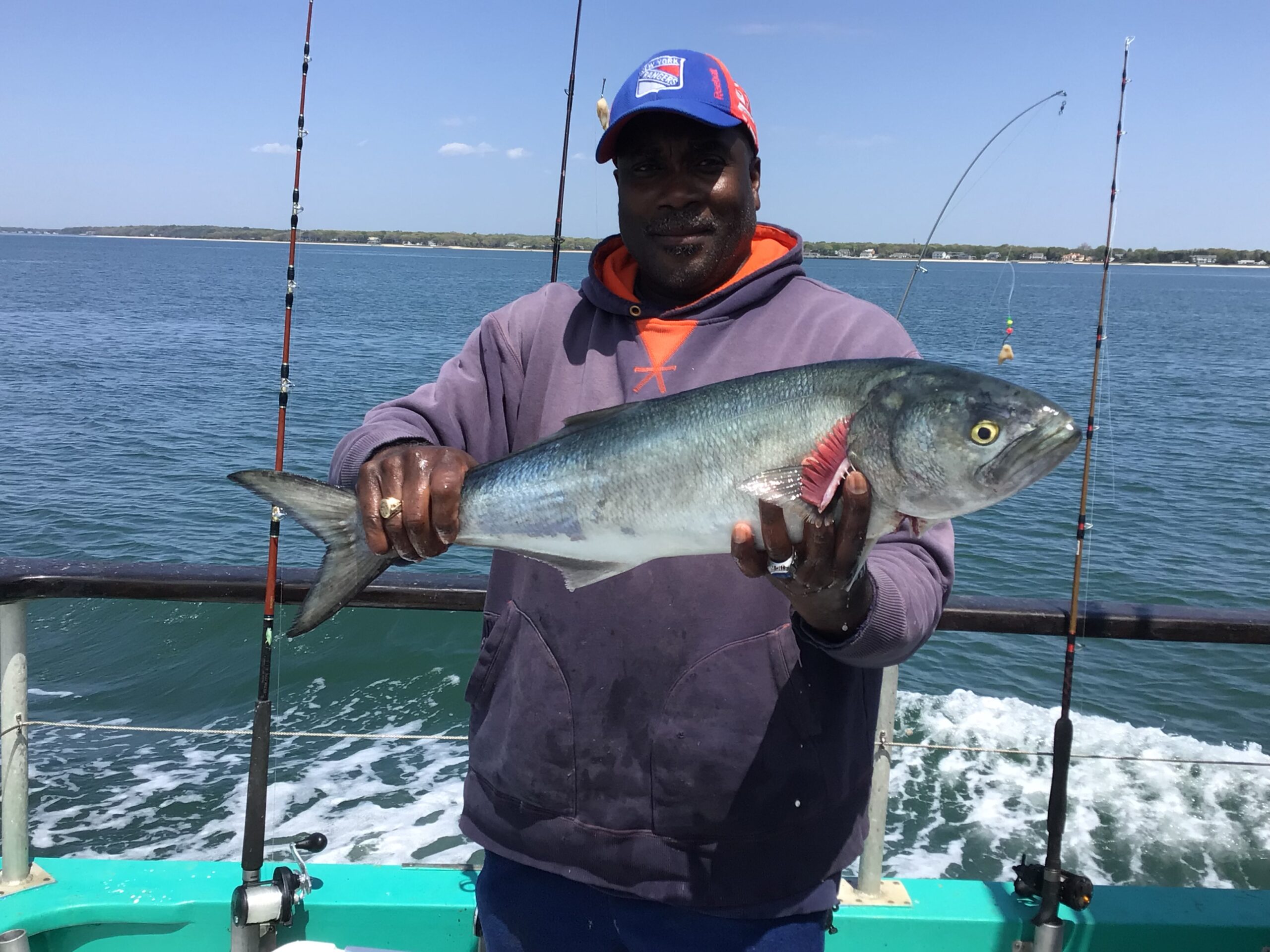 a man holding a fish on a boat in a body of water