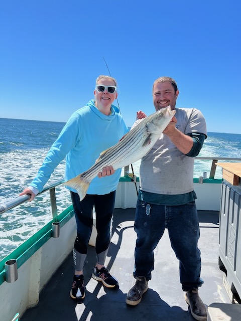 a man and a woman standing in front of water
