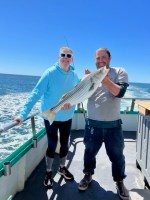 a man and a woman standing in front of water