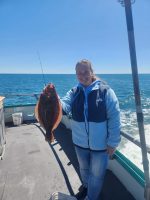 a person holding a fish on a boat in a body of water